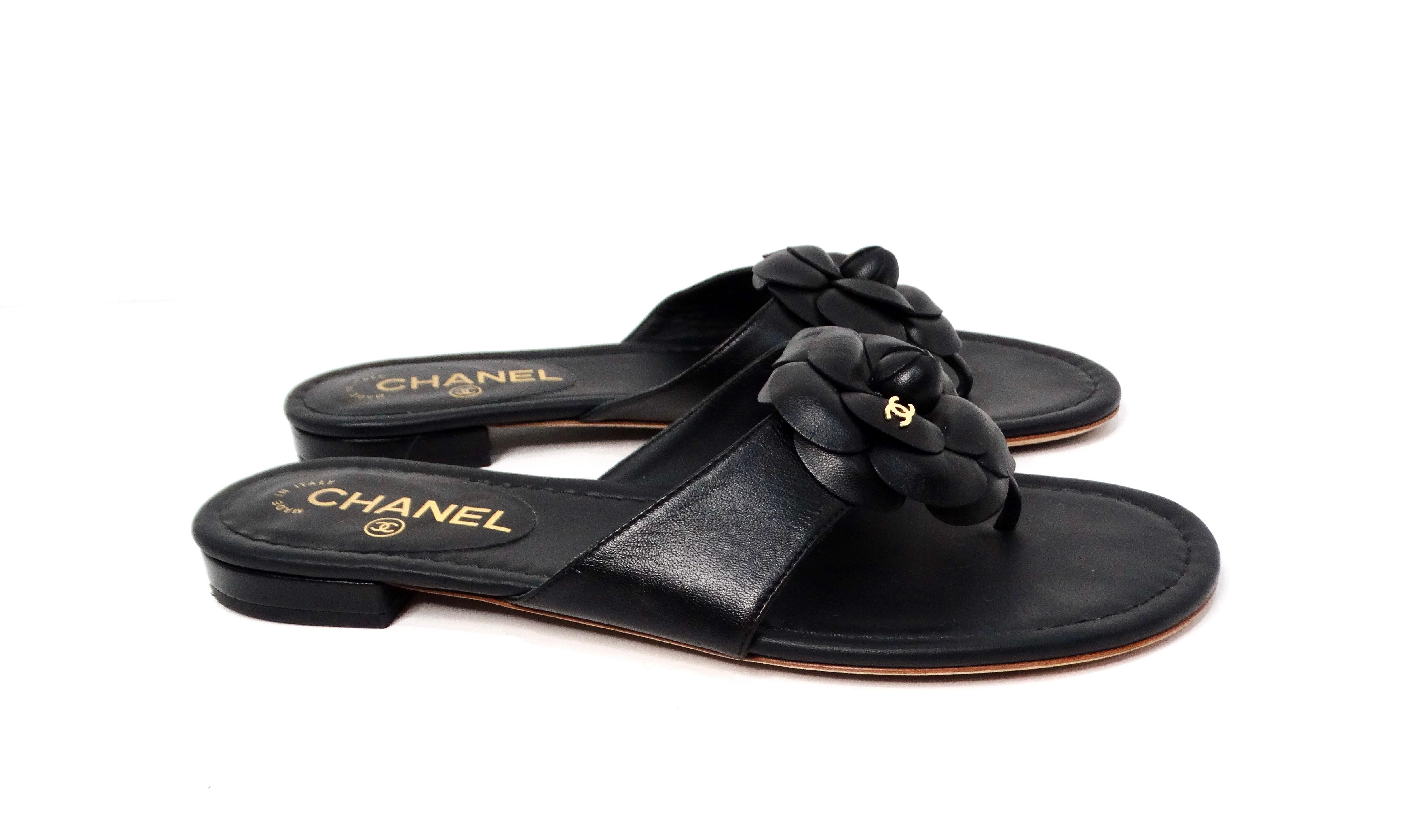 Step into luxury with the Chanel Camellia Black Lambskin Leather Sandals. These chic flip-flop sandals masterfully combine comfort and elegance, featuring exquisite black lambskin leather that feels sumptuous against the skin. The crowning glory of