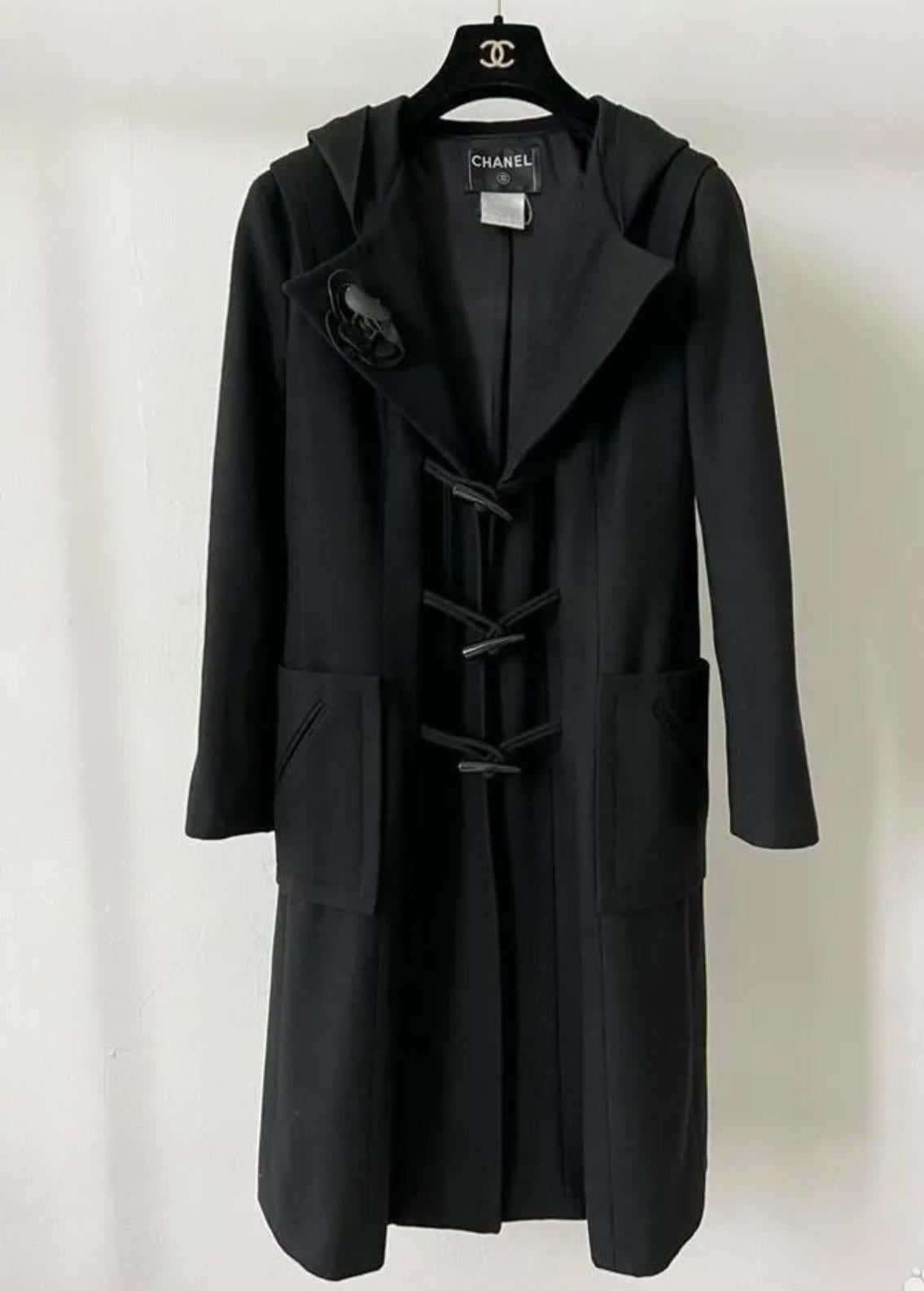 Chanel black duffle coat with Camellia Brooch.
- CC logo wooden closures
- silk lining
Size mark 42 FR. Condition is pristine.