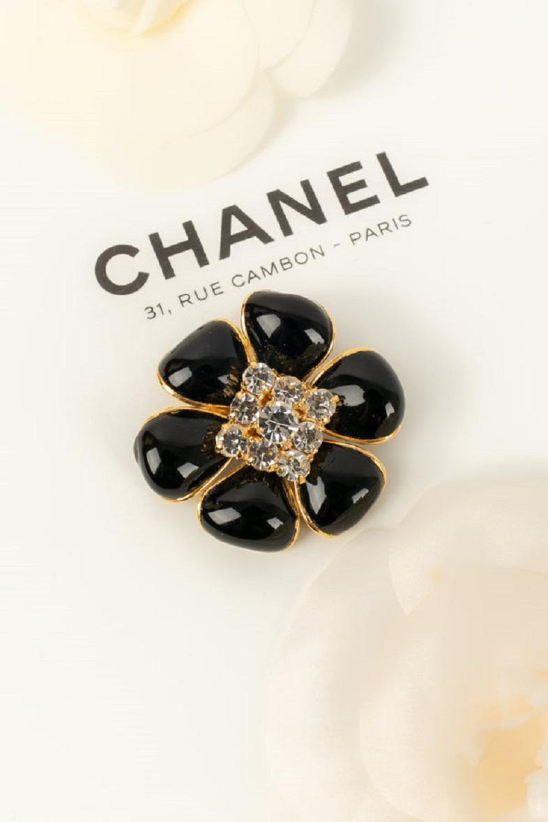 Chanel- (Made in France) Camellia brooch in gold metal, rhinestones and black glass paste. Fall-Winter 1995 collection

Additional information:
Dimensions: Ø 5 cm
Condition: Very good condition
Seller Ref number: BRB84