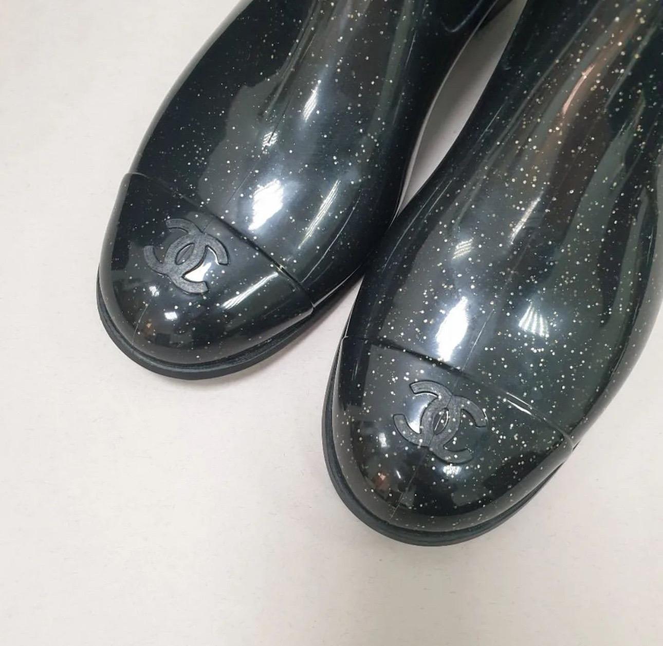 The boots are performed in high gloss rubber with glitter

Camellia flower with silver CC logo detailing

CC logo on the toe

Comfortable 1 3/4 inches heel

Removable insole leather insole

Sz.39

Never worn but have slight screches seen on pic.
No