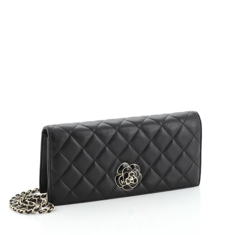 This Chanel Camellia Chain Flap Clutch Quilted Lambskin, crafted from black quilted lambskin leather, features woven-in leather chain strap, exterior back pocket and gold-tone hardware. Its double flap and frontal CC turn-lock closure opens to a