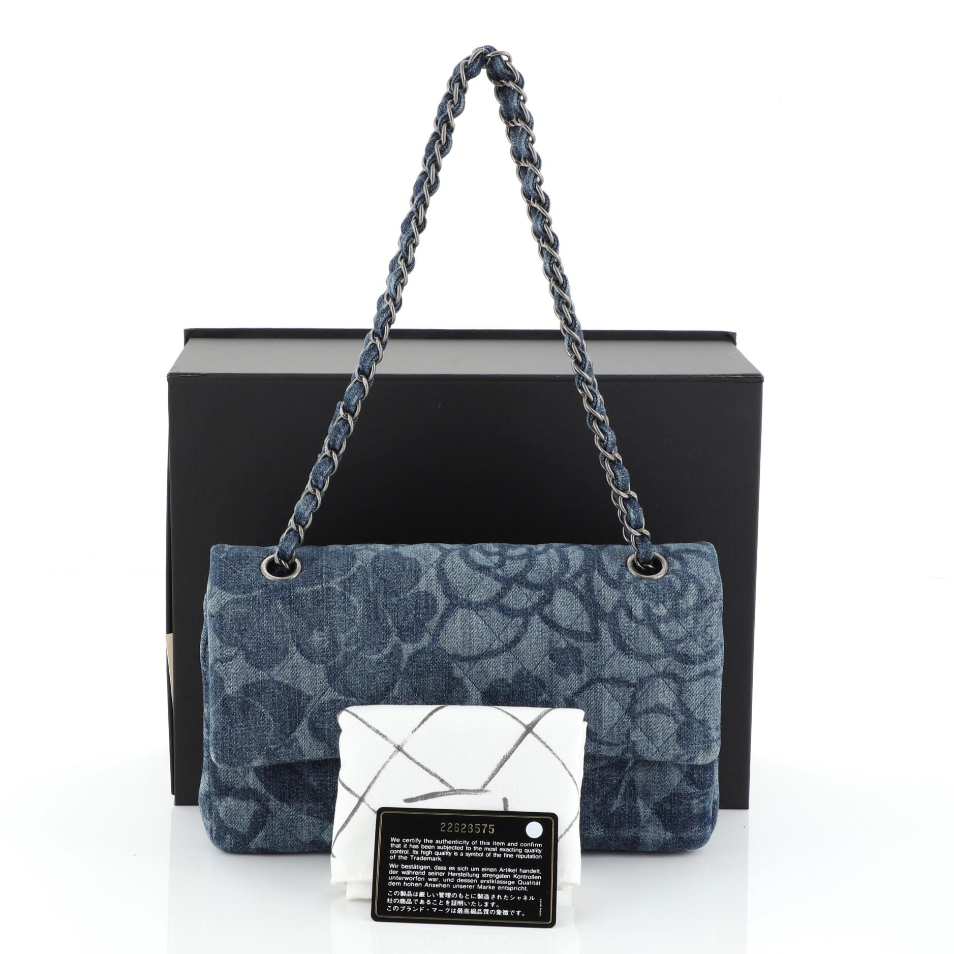 This Chanel Camellia Classic Double Flap Bag Quilted Printed Denim Medium, crafted from blue quilted printed denim, features woven-in denim chain strap, exterior back pocket and aged silver-tone hardware. Its double flap and frontal CC turn-lock
