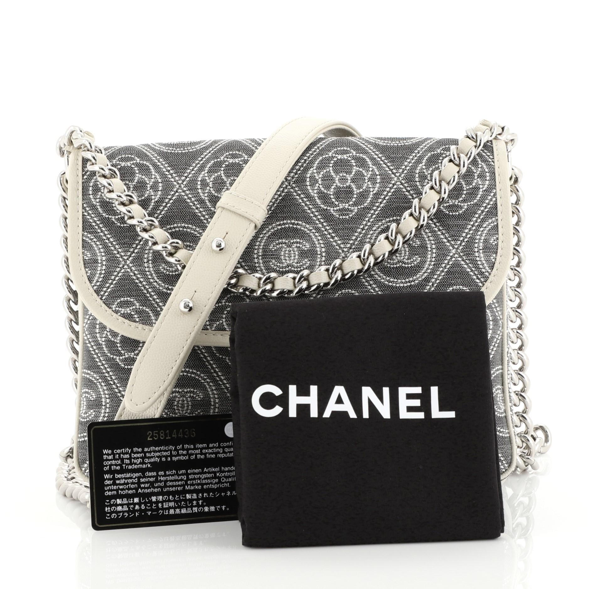 This Chanel Camellia Double Side Flap Bag Quilted Printed Canvas Small, crafted from gray quilted canvas, features chain link strap with leather pad, exterior back flap pocket, camellia and CC logo print, and silver-tone hardware. Its CC turn-lock