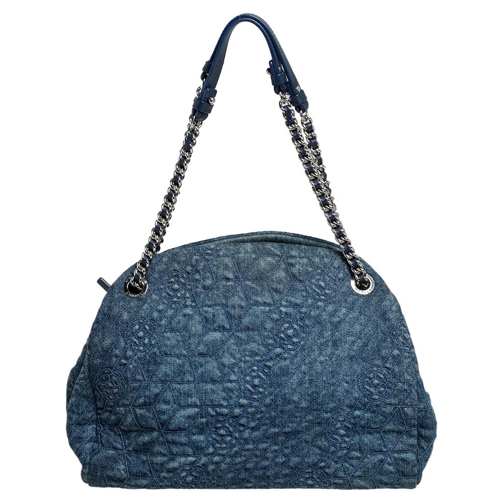 The Chanel Blue Denim Camellia Embroidered Just Mademoiselle Bowling Bag features a denim quilted exterior, a CC logo charm, and two handles. With ample room to carry your essentials, this bag brings convenience in true Chanel style.