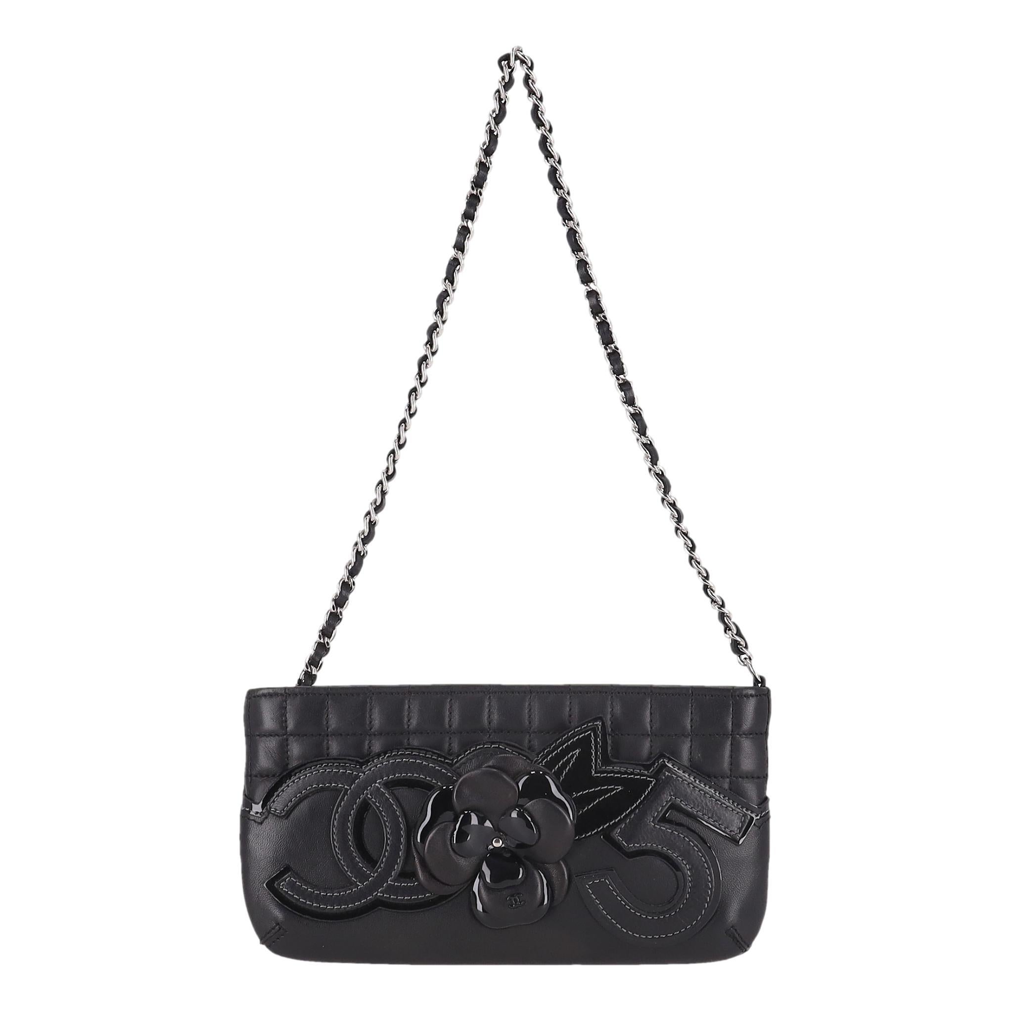 Wir bewundern - Chanel Kamelienblüte, Nr. 5 & 'CC' Logo Leder Clutch Bag an einer Kette

Schwarze Schulter-/Clutch-Tasche aus quadratisch gestepptem Lammleder.

Mit der kultigen Kamelienblüten-Applikation aus schwarzem Leder in der Mitte, dem