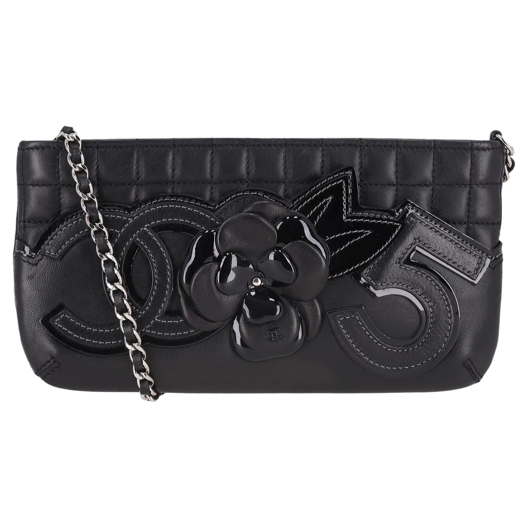Bolso de mano Chanel de piel con flor de camelia, nº 5 y logotipo "CC" en una cadena