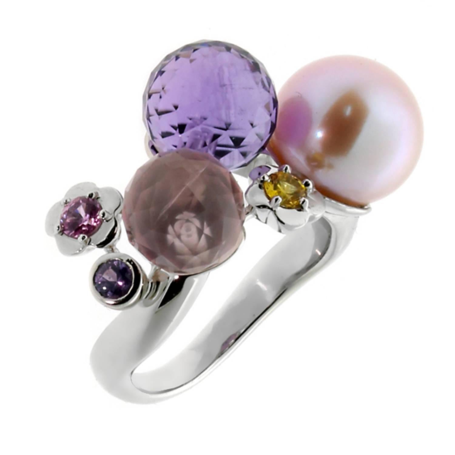El Anillo Chanel de Oro Blanco con Perla y Piedra Preciosa Camelia es una refinada mezcla de elegancia y arte. Su banda de oro blanco está adornada con cuentas facetadas de amatista y cuarzo rosa, creando un radiante diseño de inspiración floral. En