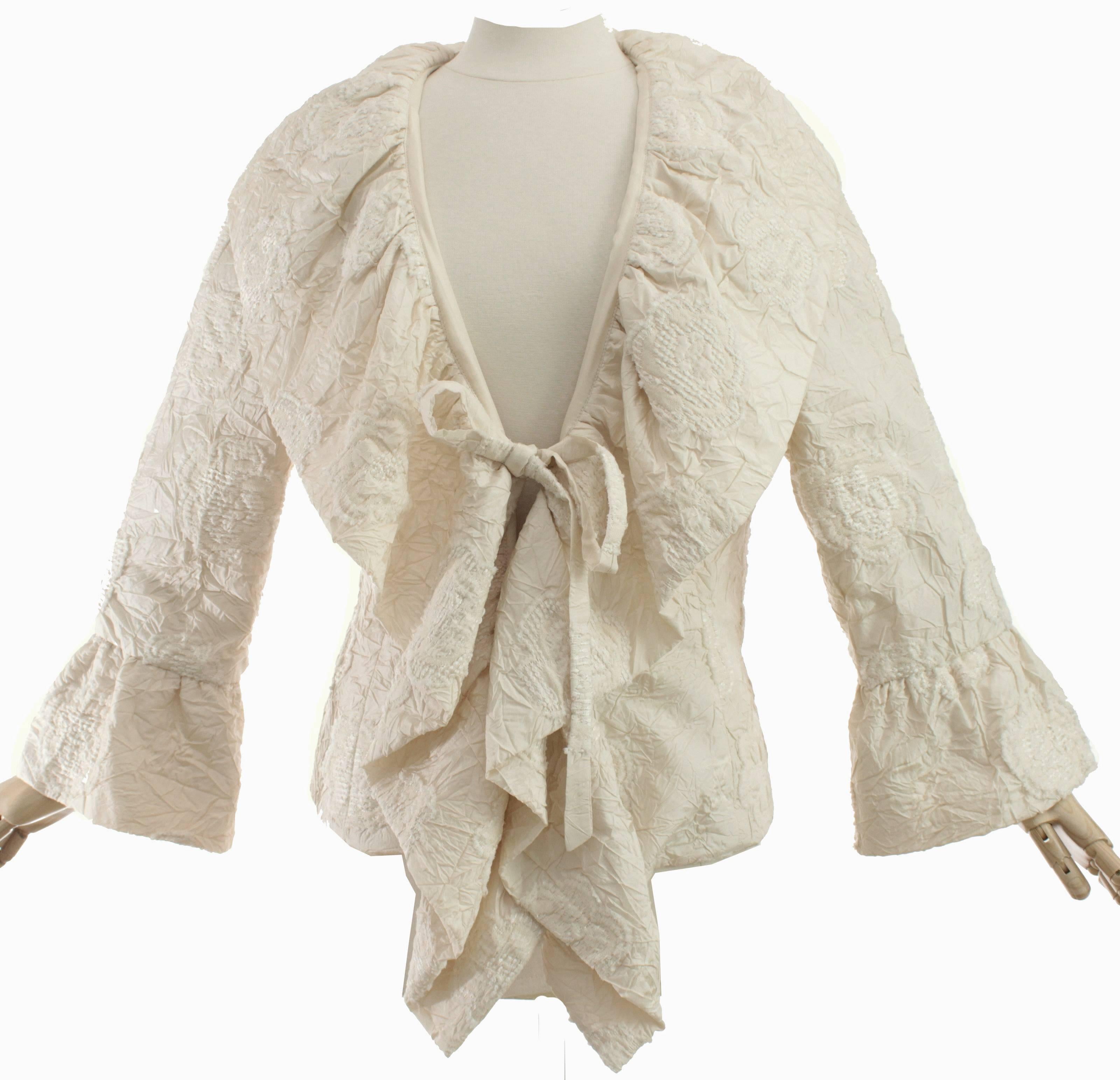 This silk jacket is made from a rich creamy ivory colored silk, with a Camellia floral motif throughout and fastens in front with embroidered ties.  The substantial collar goes all the way to the hem and can be propped up or worn down,  Each sleeve