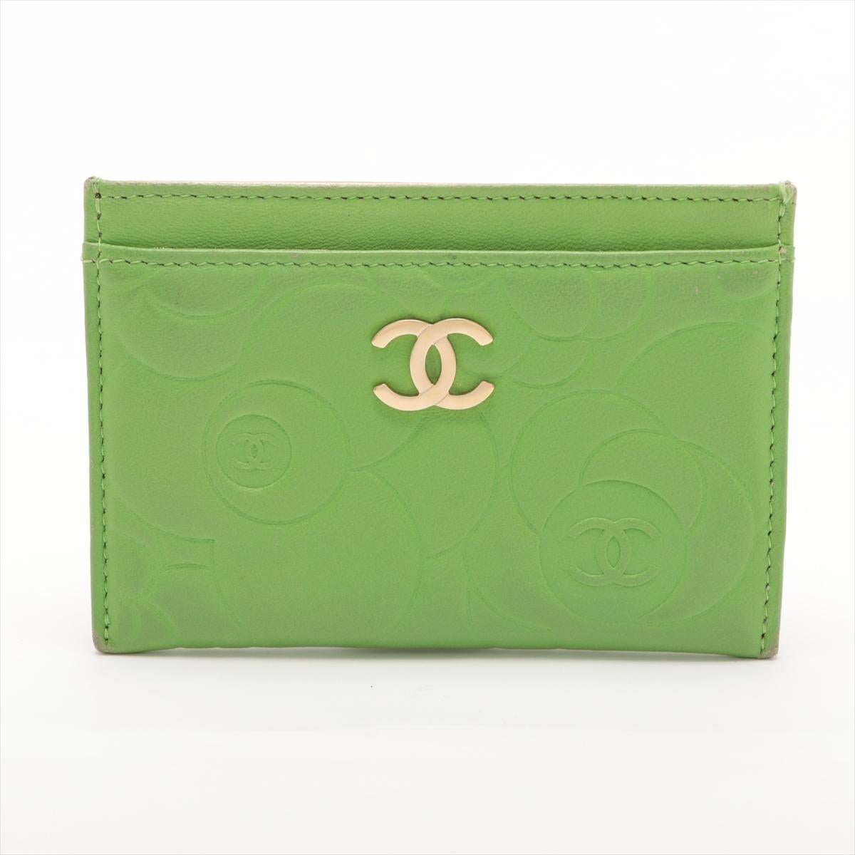 The Chanel Camellia Lambskin Card Case in Apple Green is a chic and elegant accessory that blends functionality with luxury. Crafted from soft lambskin leather, the card case features Chanel's signature Camellia flower design, adding a touch of