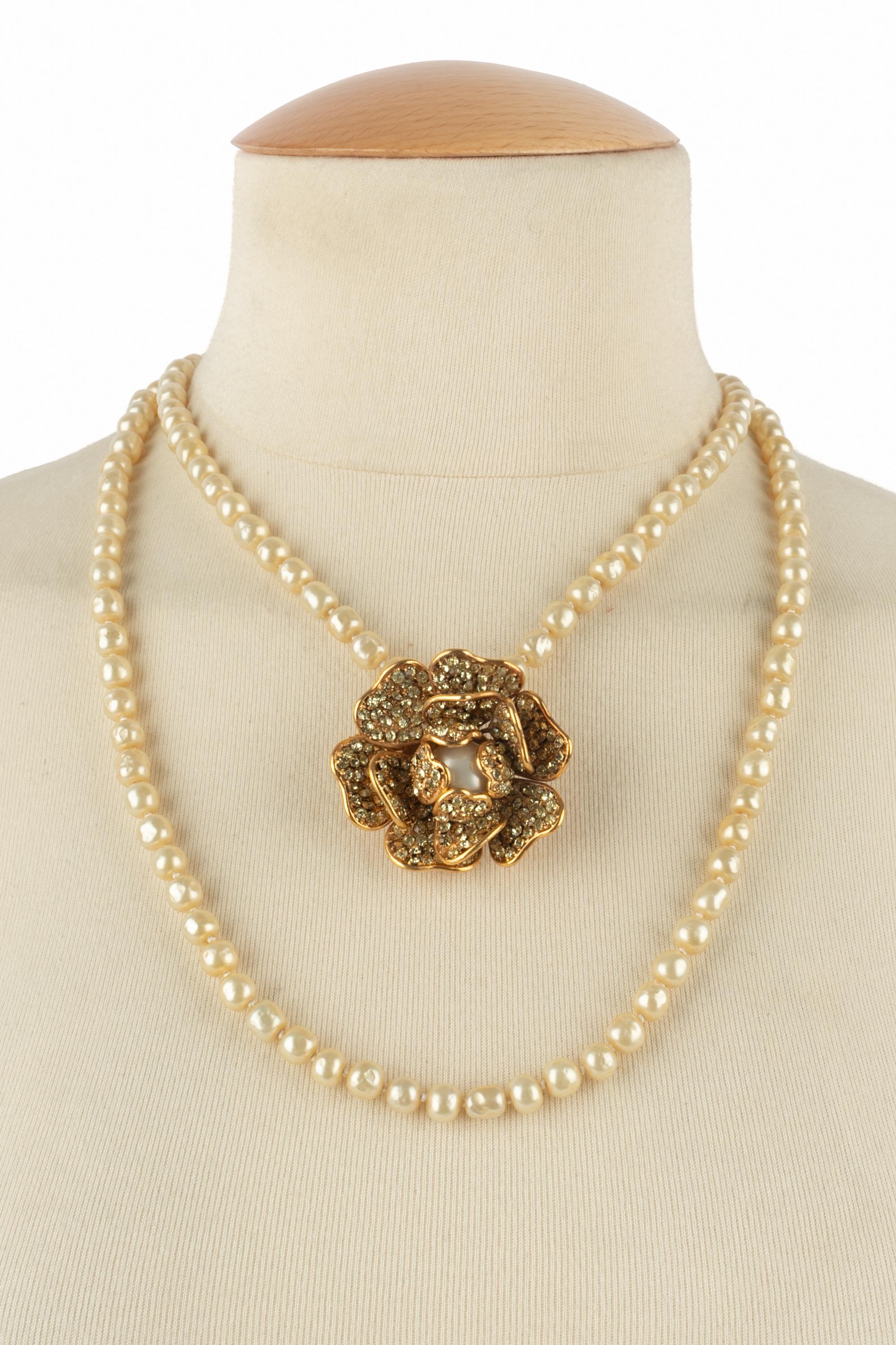 Chanel - (Made in France) Collana di perle in costume assemblate con nodi, con un medaglione in metallo dorato strassato che rappresenta una camelia. Gioielli degli anni '80.

Condizioni:
Ottime condizioni

Dimensioni:
Lunghezza: 110 cm - Camelia: 5