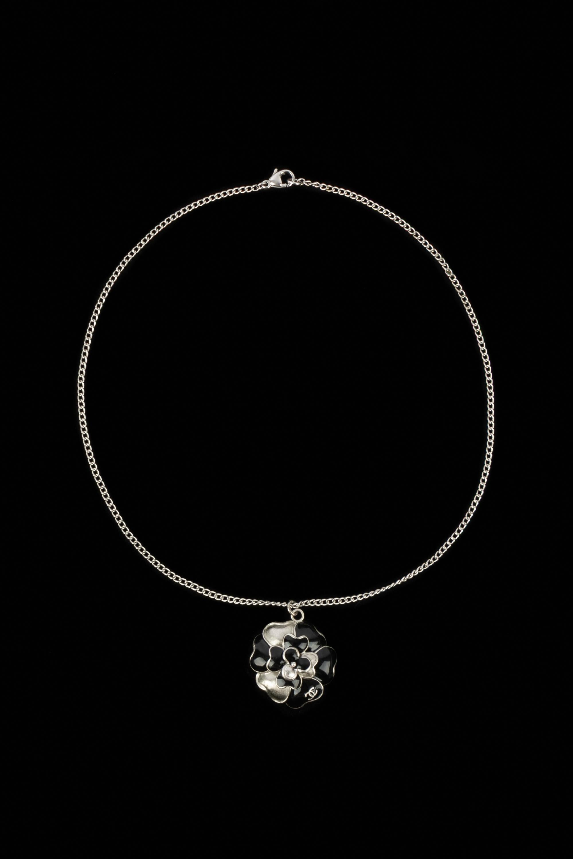 Chanel - (Made in France) Collana in metallo argentato con un ciondolo a forma di camelia smaltato di nero. Collezione Primavera-Estate 2007 sotto la direzione artistica di Karl Lagerfeld.

Condizioni:
Ottime condizioni

Dimensioni:
Lunghezza: 41