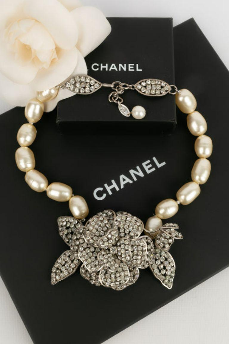 Chanel -(Made in France) Necklace of pearly pearls and camellia in silver plated metal and strass. Collection 1984. To note, rare marks on the mother-of-pearl.

Additional information: 
Dimensions: Length : from 46 cm to 49 cm
Condition: Very good