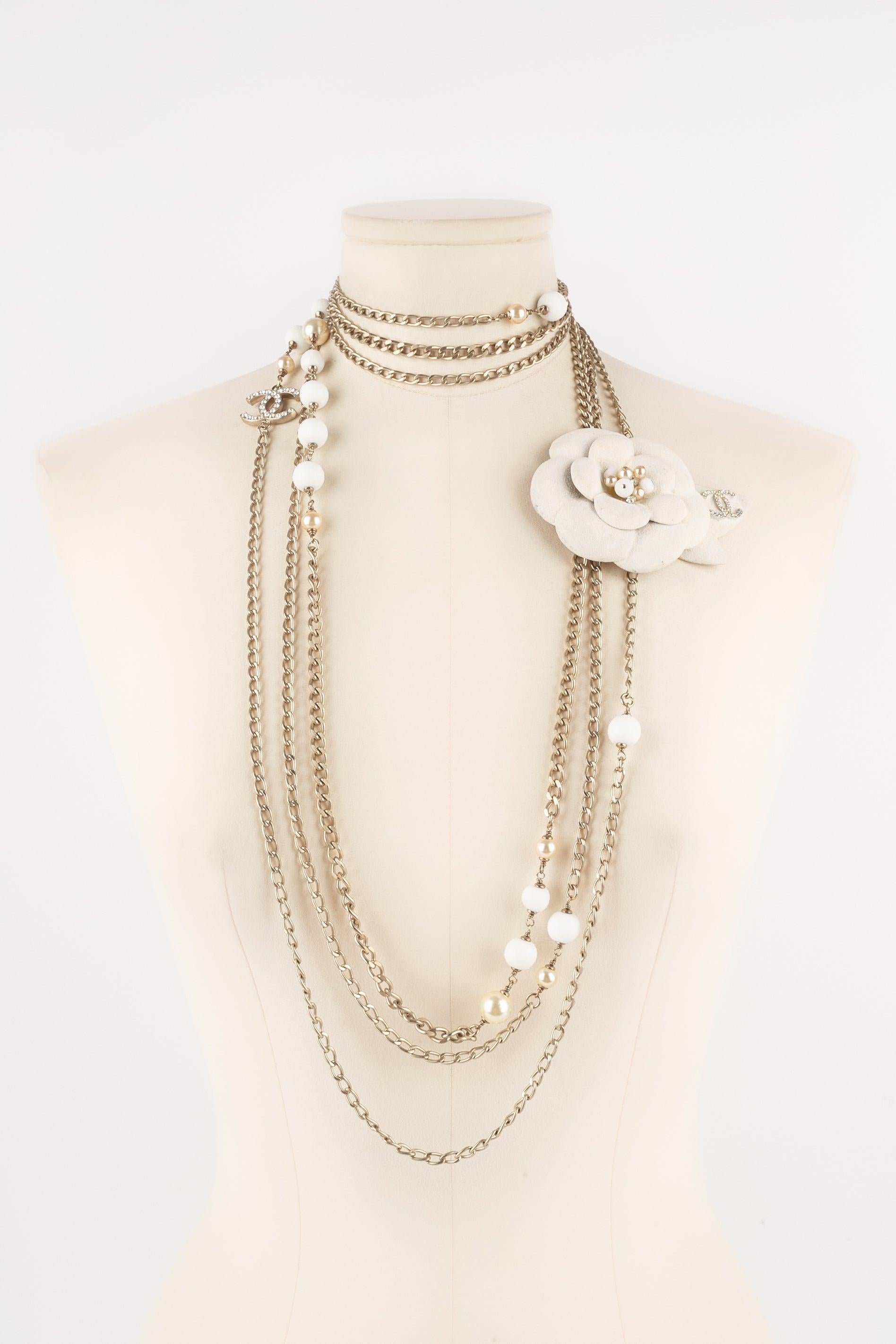 Chanel - (Made in France) Silvery metal camellia necklace with costume pearls and snow-like pearls. The medallion is also sprayed with a snow-like material. 2005 Fall-Winter Collection. To be mentioned, the medallion has dirty marks and the tiny