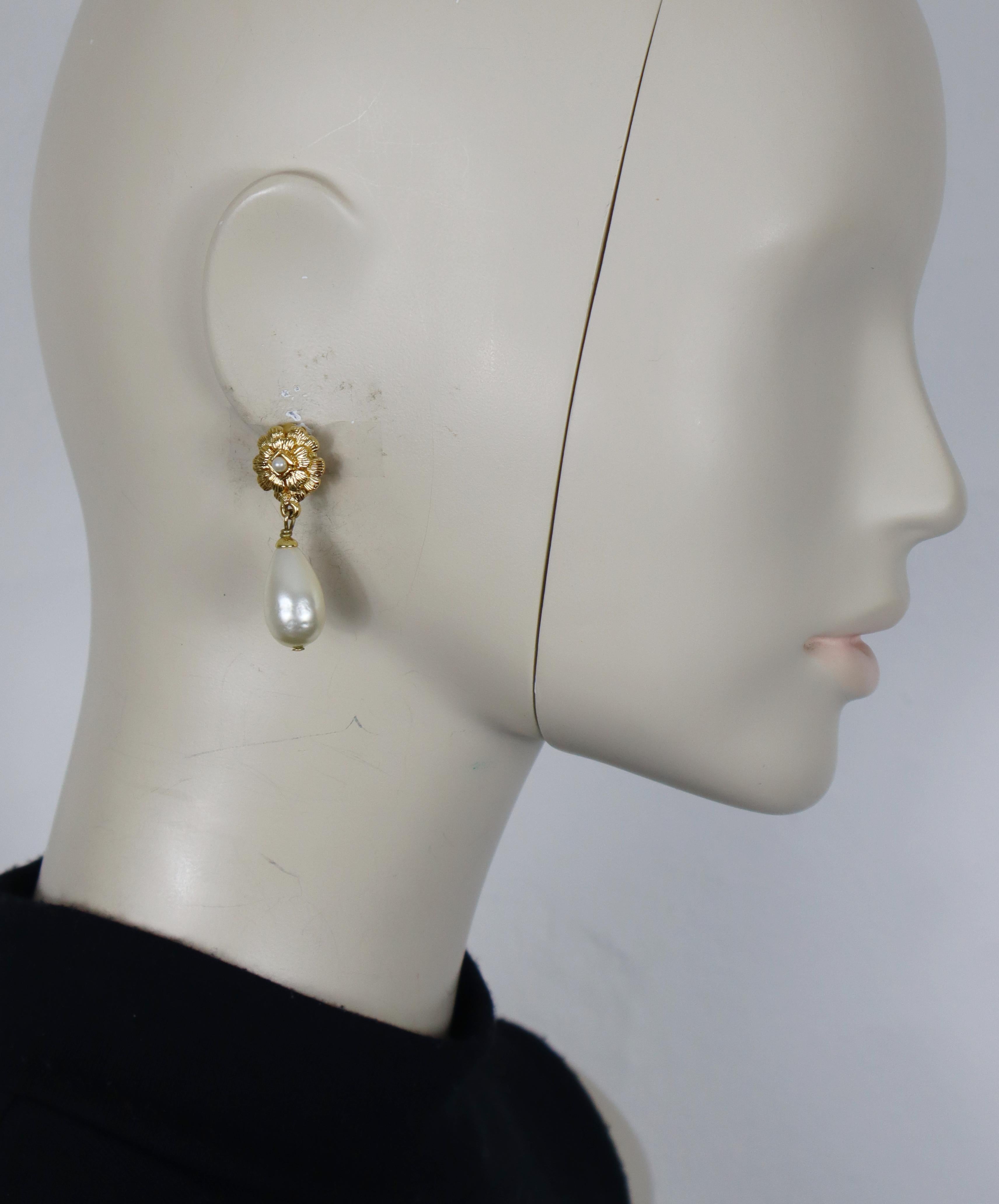 CHANEL gold tone camellia dangle earrings (clip-on) embellished with a little faux pearl and a faux pearl drop.

Fall 1995 Collection.

Embossed CHANEL 95 A Made in France.

Indicative measurements : height approx. 4.2 cm (1.65 inches) / max width