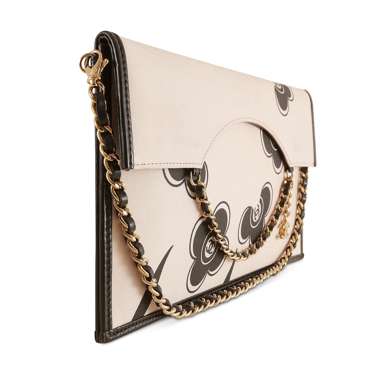 Chanel Camellia Silk and Leather Pochette- limited edition; excellent plus condition
 A removable strap enhances the versatility- it may be carried as a clutch or shoulder bag.  
Cream silk slim flap bag is edged with sturdy black leather.  Adorned