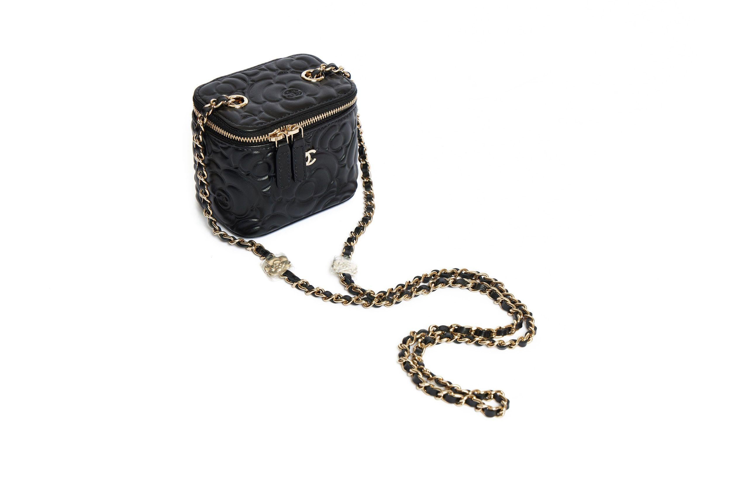 Chanel Mini Vanity Case bag in black with embroidered Camellia pattern. This bag is brand new so that the small flowers on the shoulder leather-threaded gold chain (drop 22’) are still covered in plastic. The bag closes with a zip and in front is
