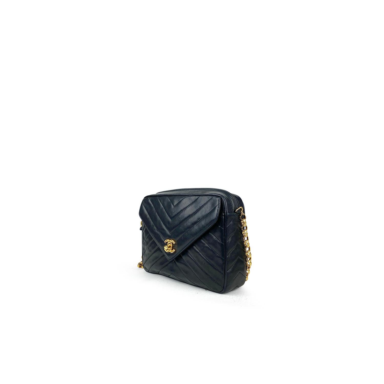 Black leather Chanel Camera crossbody bag with

- Gold-tone hardware
- Single chain-link shoulder strap
- Single exterior pocket at front featuring CC turn-lock closure
- Tonal leather lining, dual pockets at interior walls; one with zip closure and