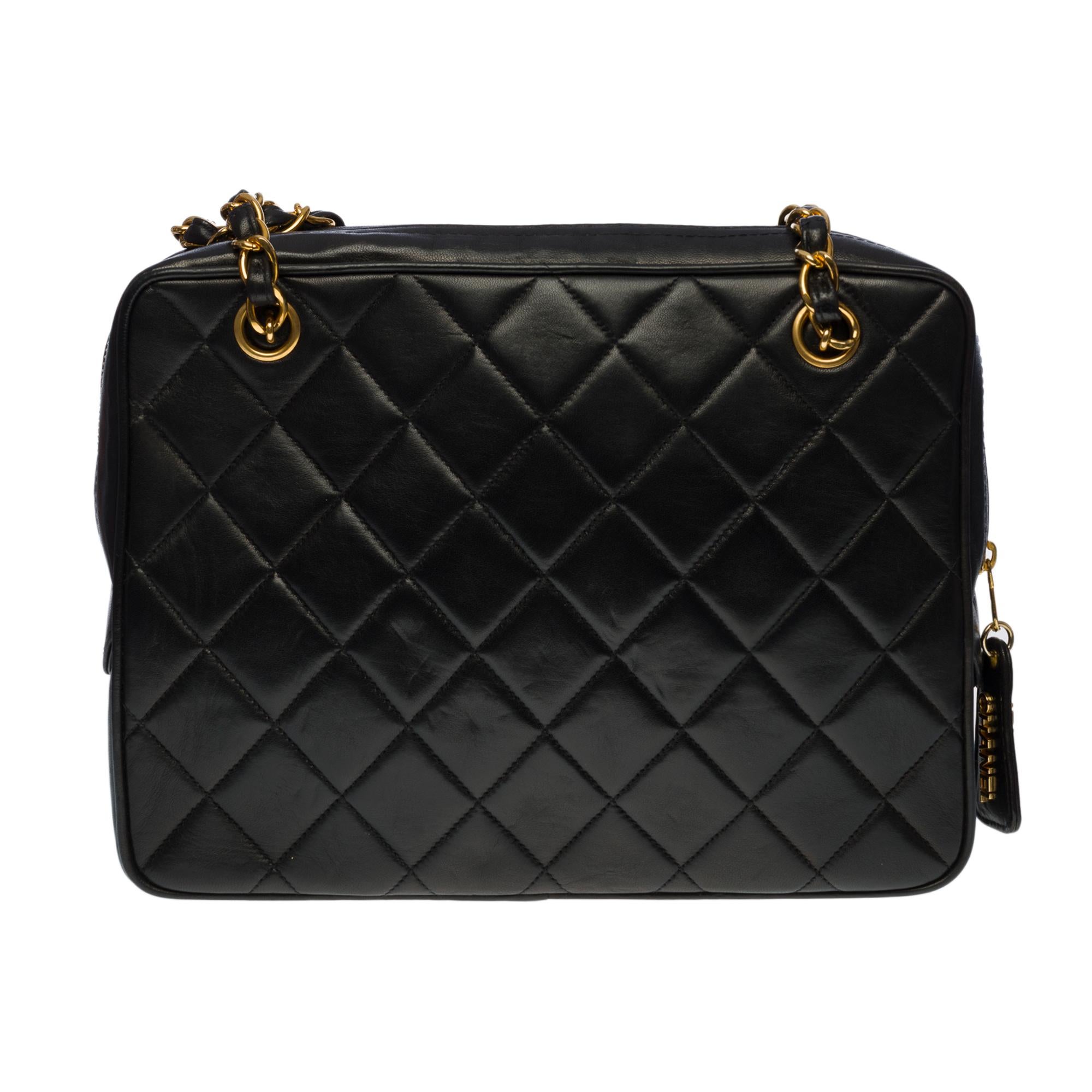 Sublime Chanel Camera Front Pocket GM shoulder bag in black quilted lambskin leather, gold-tone hardware, two gold-tone metal chain handles interlaced with black leather for shoulder support
Zipper closure, adorned with a leather pull tab with the