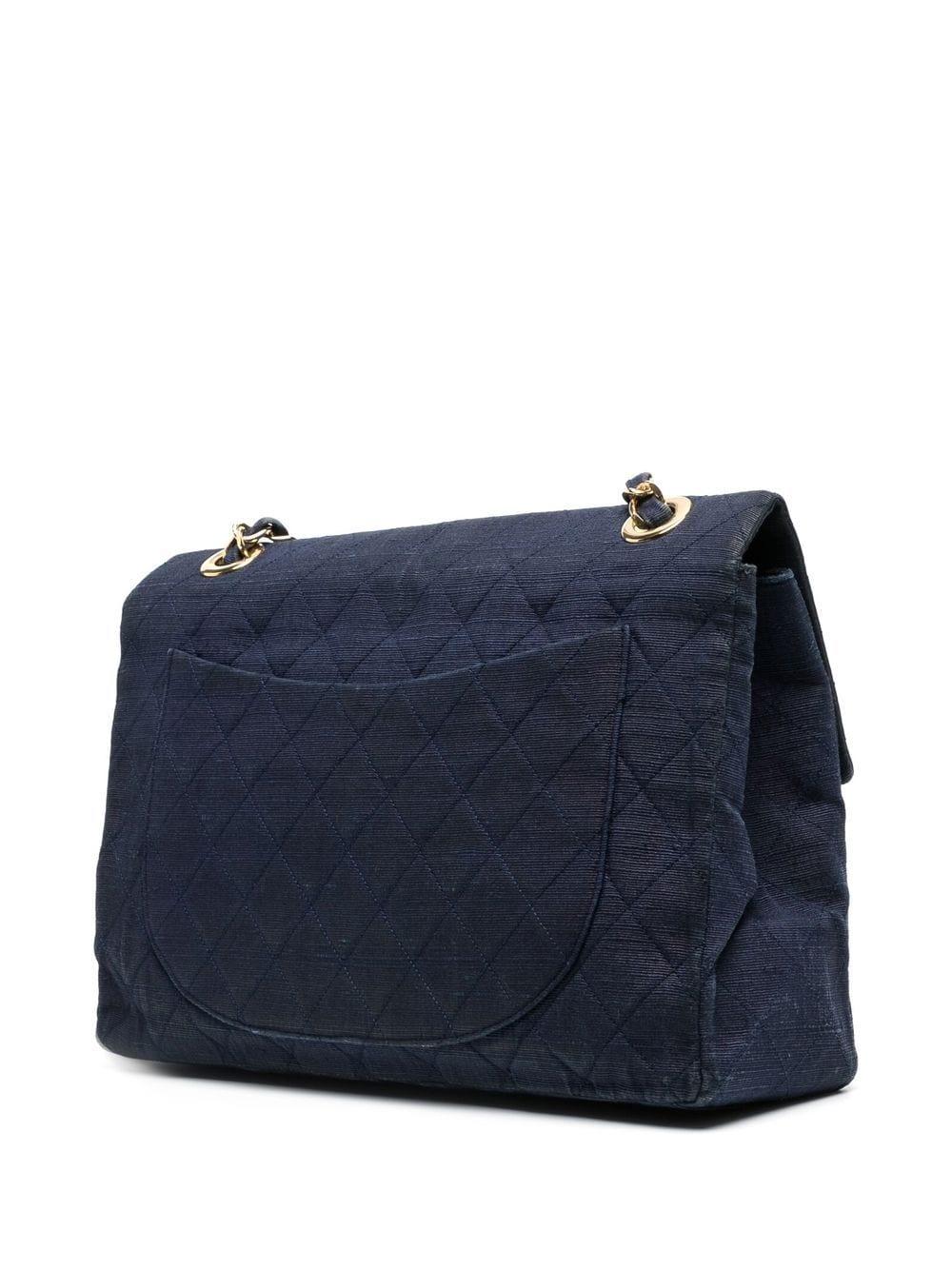 This rare vintage Maxi Flap bag from 1991-1994 has been crafted from dark navy cotton canvas for a more casual and practical look. Designed with the Maisons signature diamond quilting and CC logo, the bag features a large leather-lined main