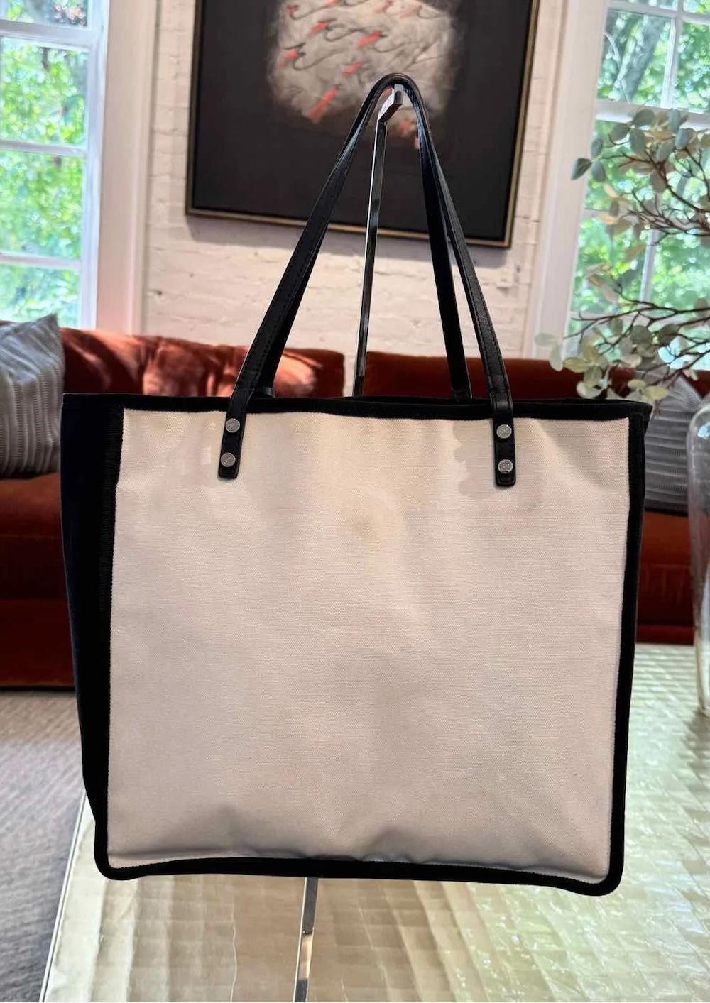 The Chanel Tote is from the Spring/Summer 2015 Collection by Karl Lagerfeld. It is made of black and white canvas featuring the interlocking CC logo and silver-tone hardware. The bag has dual shoulder straps and leather trim embellishment. Inside,