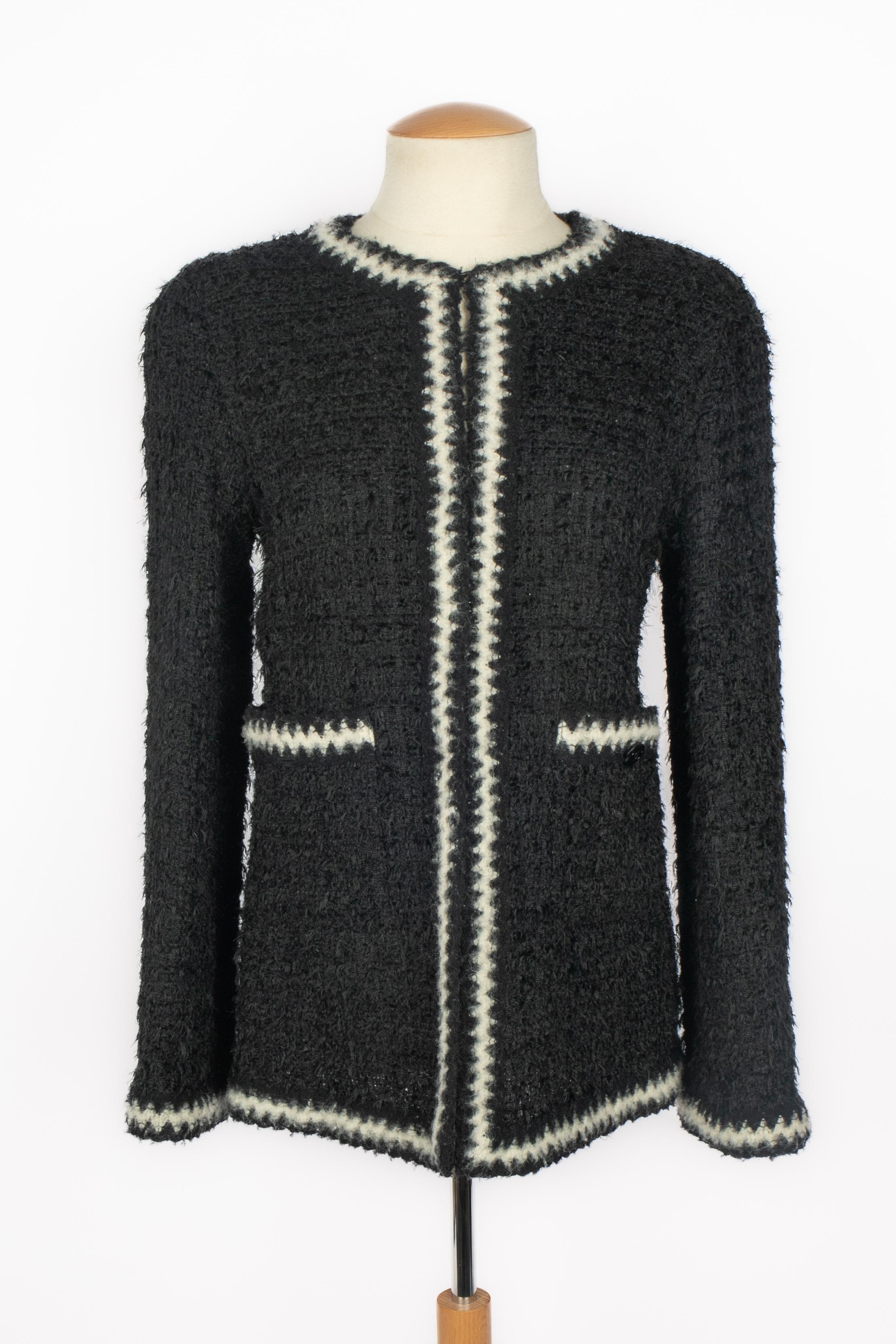 CHANEL - Veste cardigan en tweed noir bordée d'un galon de laine noir et blanc. Aucune taille n'est indiquée, il convient à un 36FR.

Condit :
Très bon état.

Dimensions :
Largeur des épaules : 38 cm - Poitrine : 44 cm - Longueur des manches : 60 cm