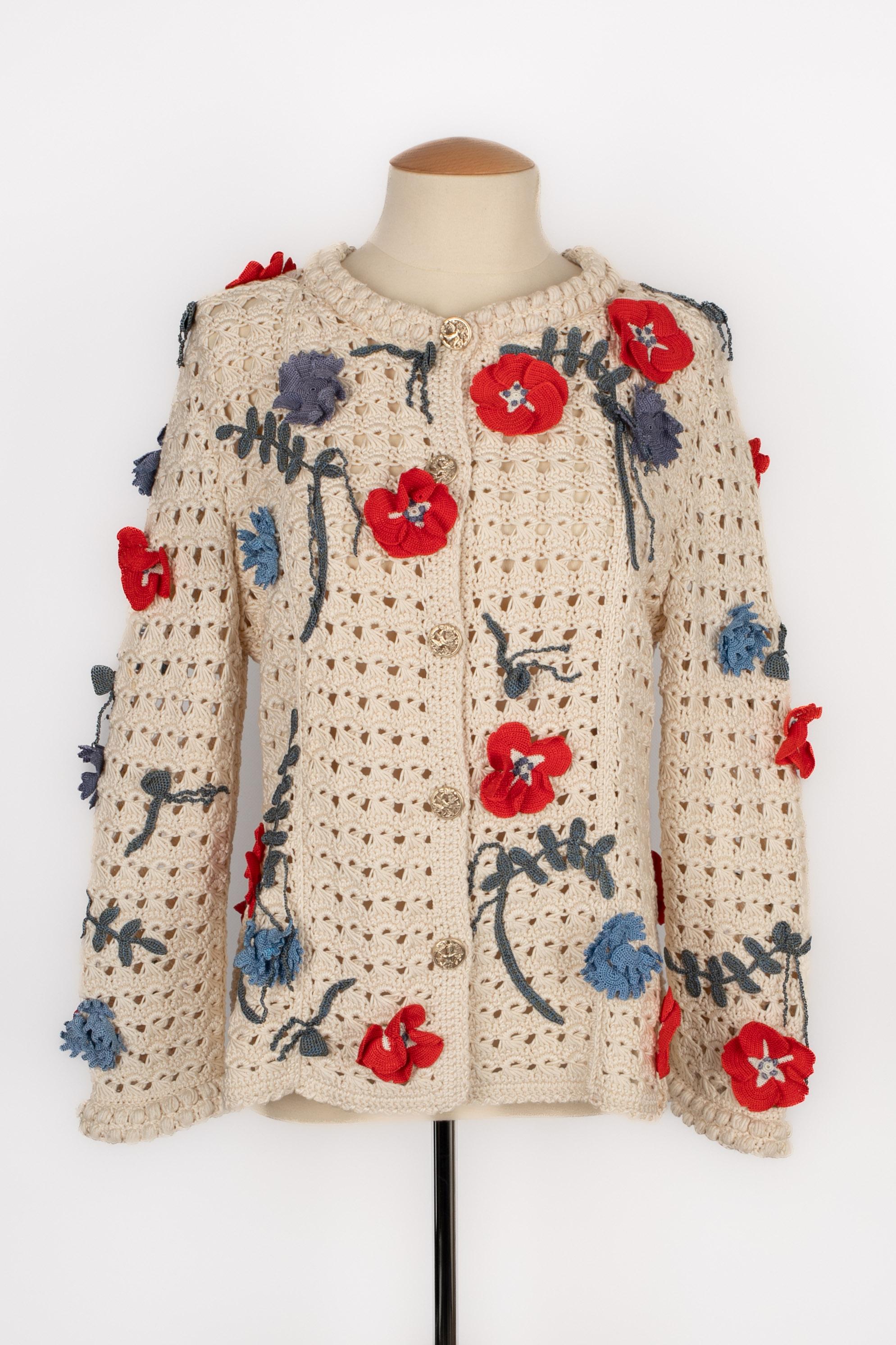 CHANEL - (Made in Italy) Rebeca de ganchillo beige decorada con flores rojas y azules. Talla 38FR indicada. Colección Primavera-Verano 2010 bajo la dirección artística de Karl Lagerfeld.

Estado:
Muy buen estado

Dimensiones:
Anchura de los hombros: