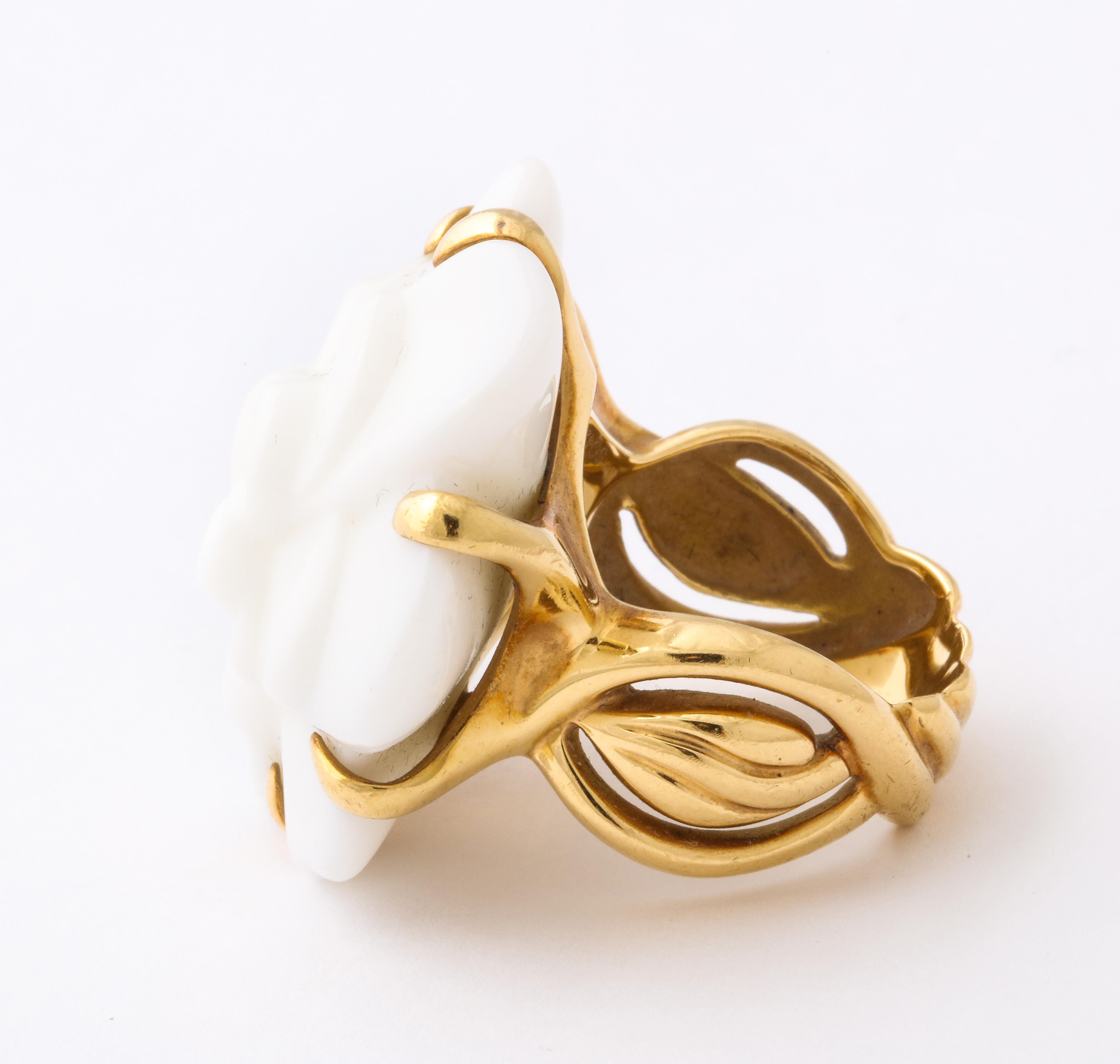 We offer a vintage Chanel fashion ring of 18K gold holding a large camellia flower blossom of carved white agate, measuring 1 1/4 inch diameter, weighing 23.79 grams. Fits finger size 7 1/2, and signed CHANEL. Gold and makers marks. The ultra chic