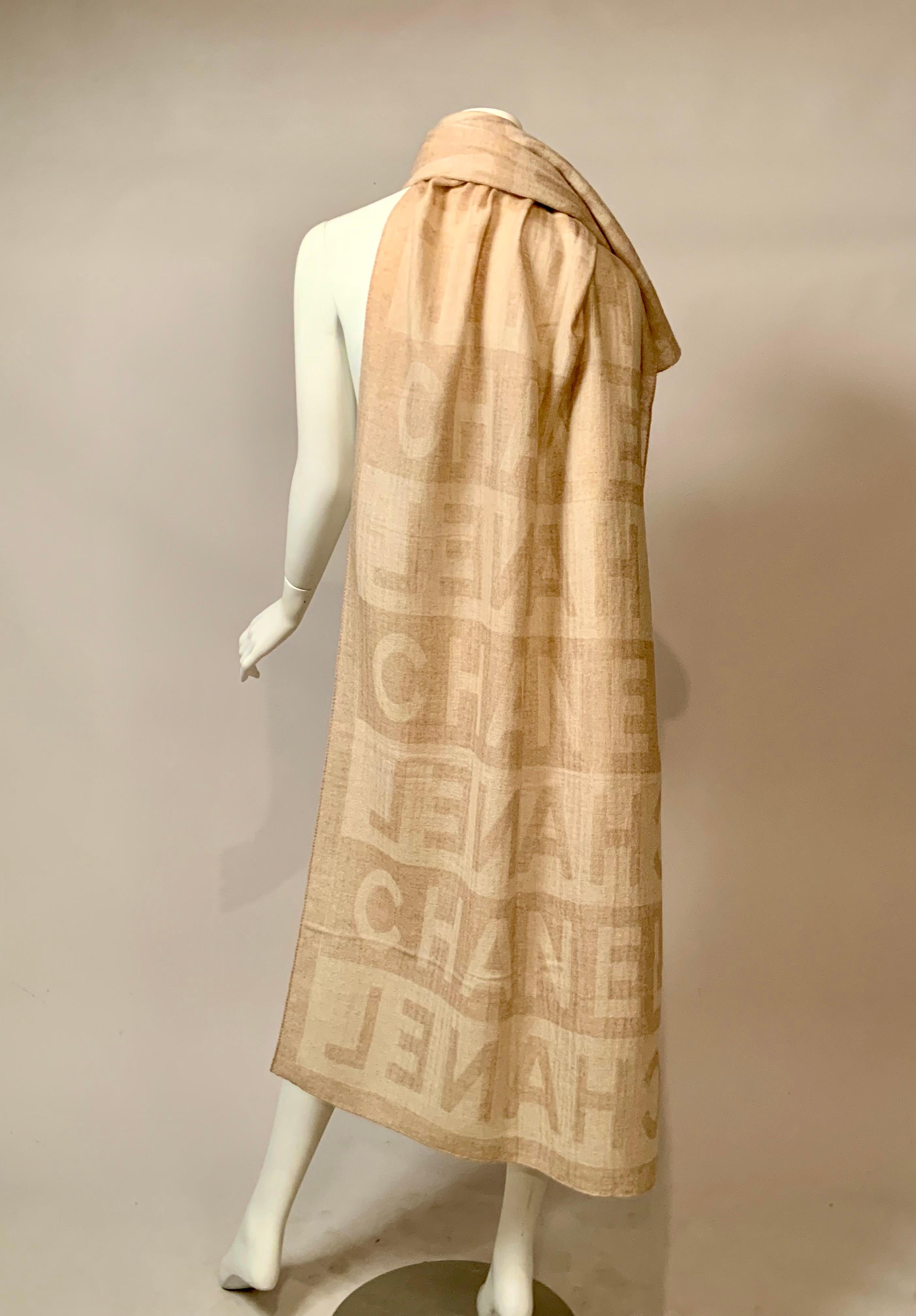 Este elegante chal de cachemira y seda bicolor beige de Chanel tiene un sutil estampado del logotipo de Chanel.  Se teje al derecho y al revés, de modo que el chal no tiene ningún revés.  Es un rectángulo largo, hecho con la mezcla más suave de 70%