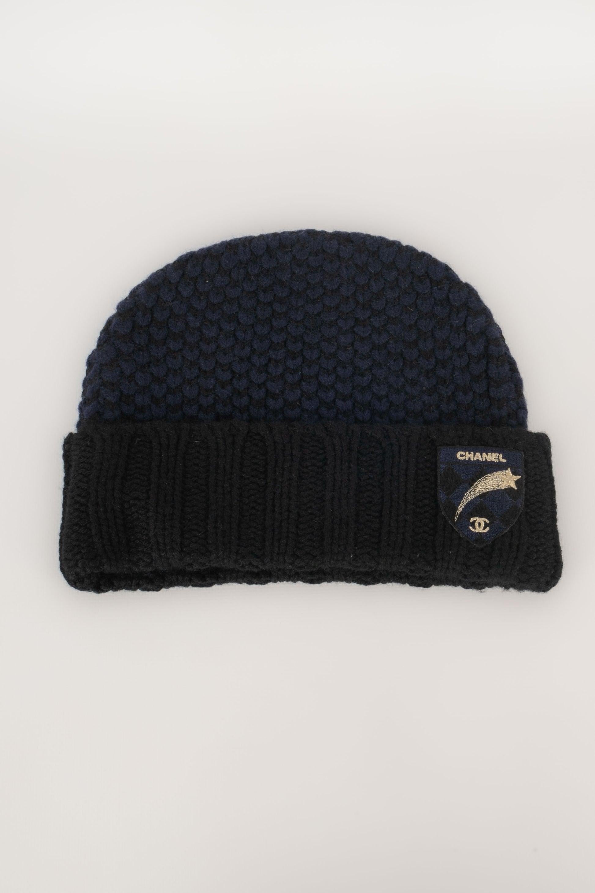 Chanel - (Made in Scotland) Cashmere beany hat decorated with an embroidered shield.

Additional information:
Condition: Very good condition
Dimensions: Head circumference: 54 cm

Seller Reference: CHP88