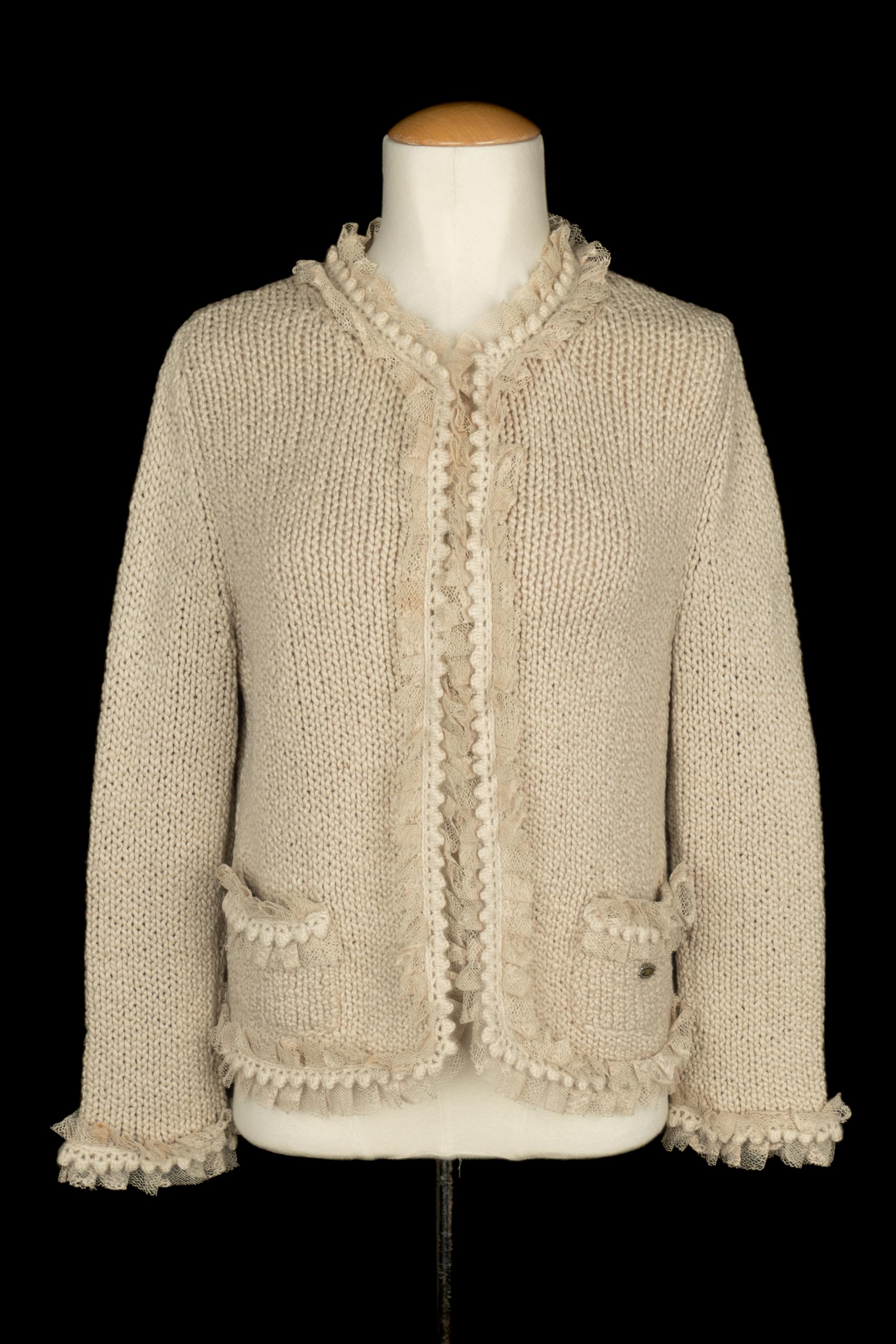 CHANEL - Cardigan en cachemire et dentelle beige. L'étiquette de la taille est manquante, il s'agit d'un 38FR. Pièce du début des années 2000 sous la direction artistique de Karl Lagerfeld.

Condit :
Très bon état.

Dimensions :
Largeur des épaules