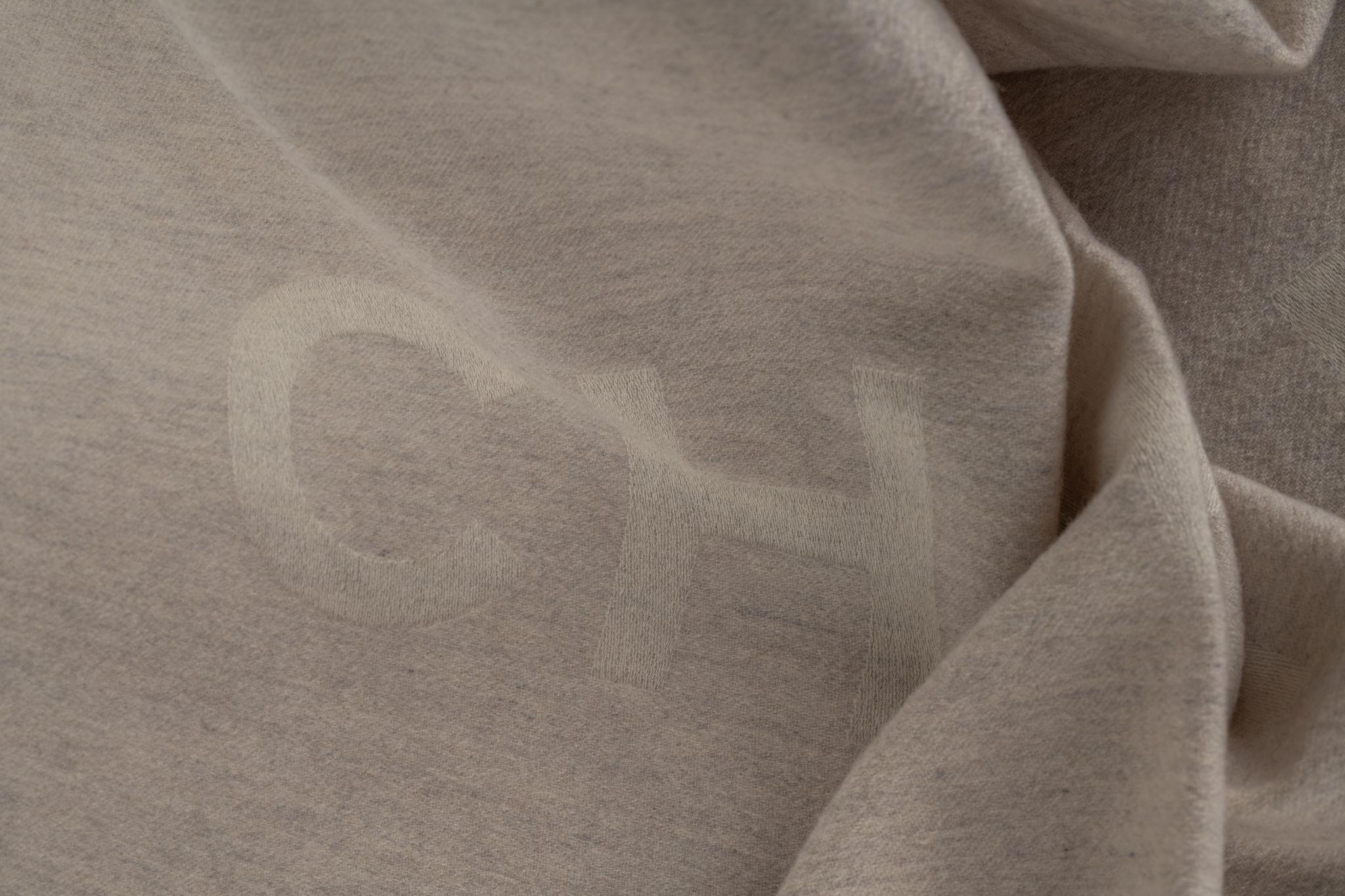 Chanel creme cashmere shawl with Chanel written on it. The scarf is in excellent condition.