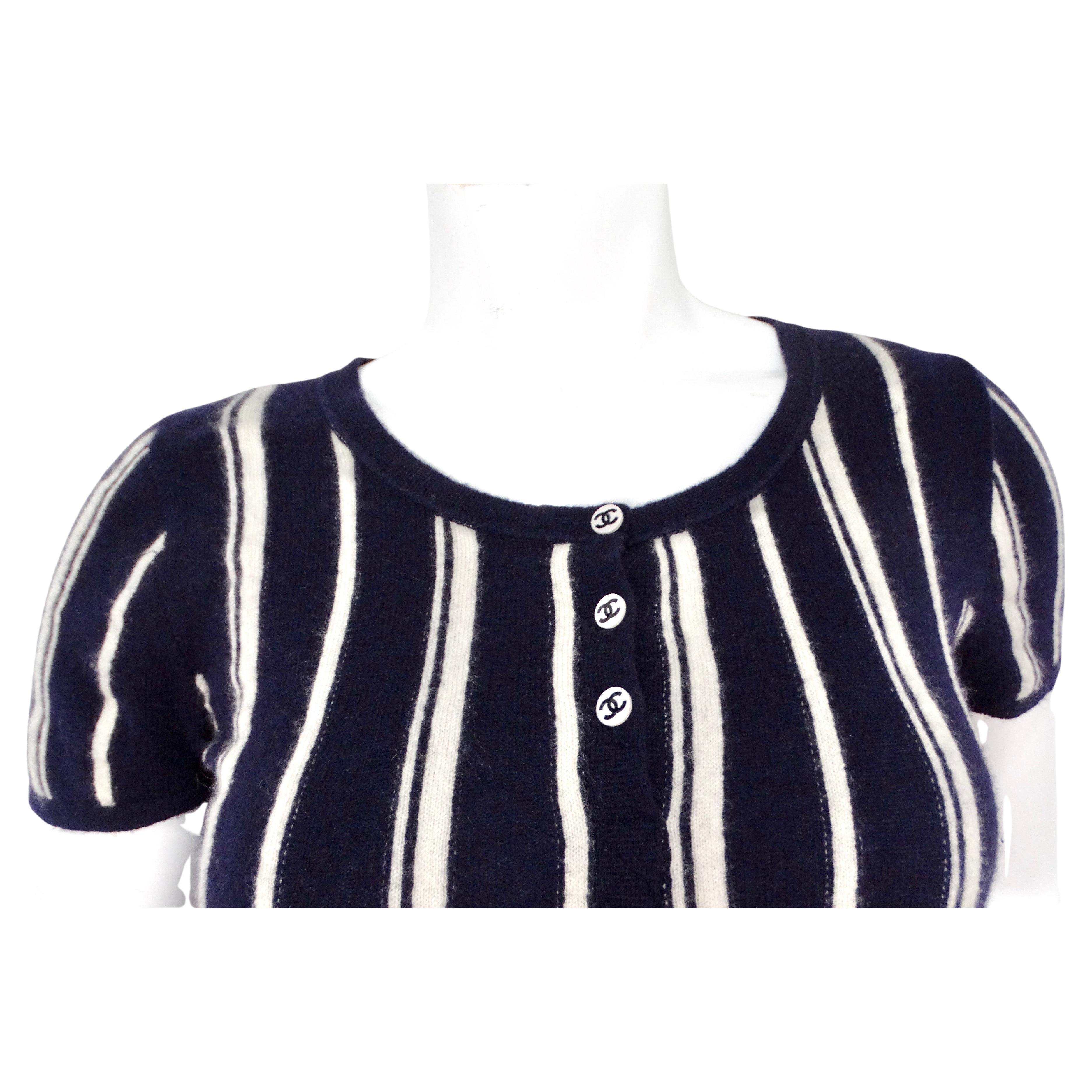 Il top Chanel Cashmere a righe bianche e blu navy con bottoni del 2003 è un pezzo elegante e senza tempo che esemplifica l'impegno di Chanel per la lavorazione di lusso e lo stile classico. Realizzato in sontuoso cashmere, questo top offre una
