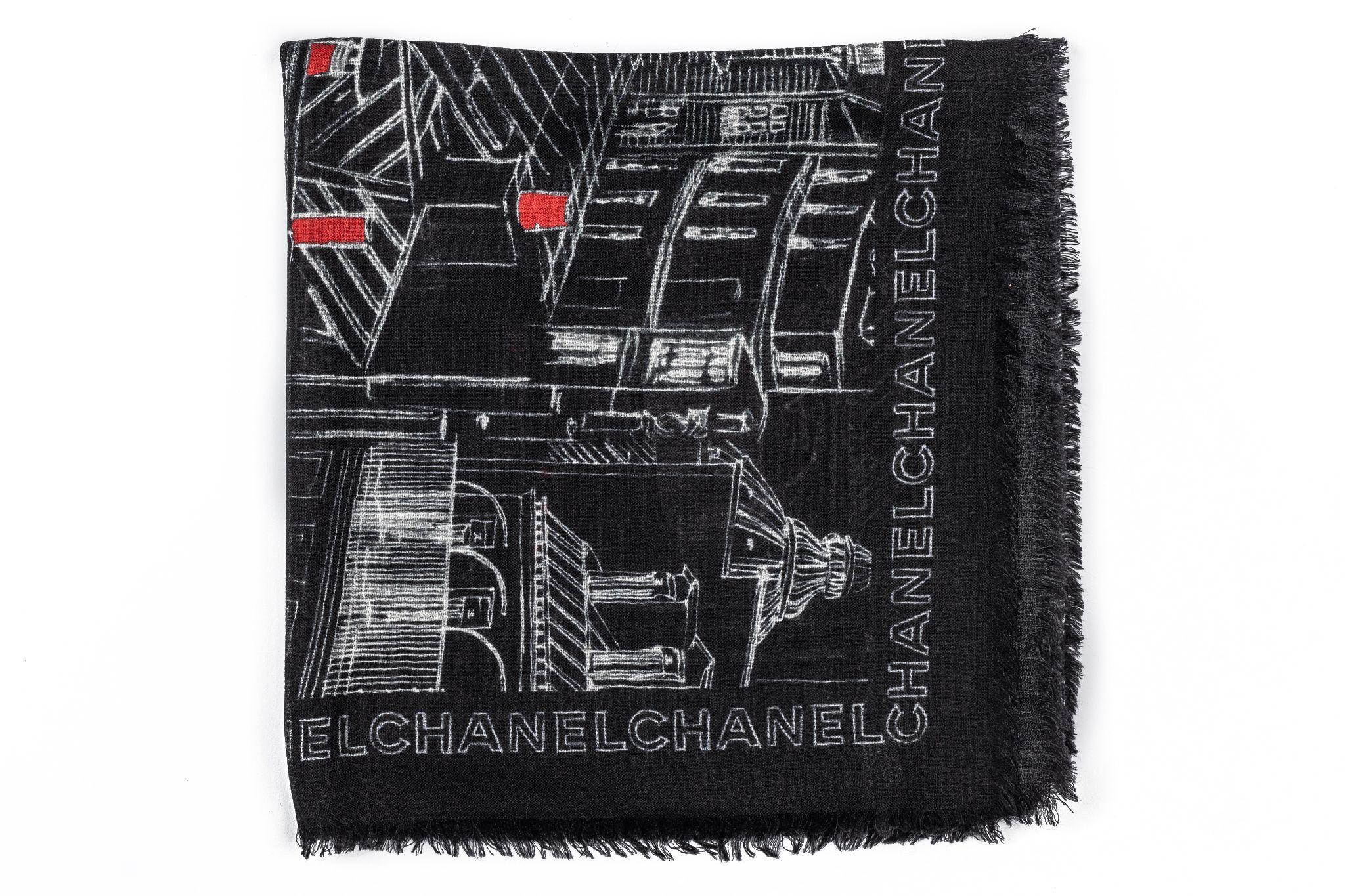Chanel Cashmere Shawl in black featuring a print of Paris and framed with Chanel writings. In new condition.