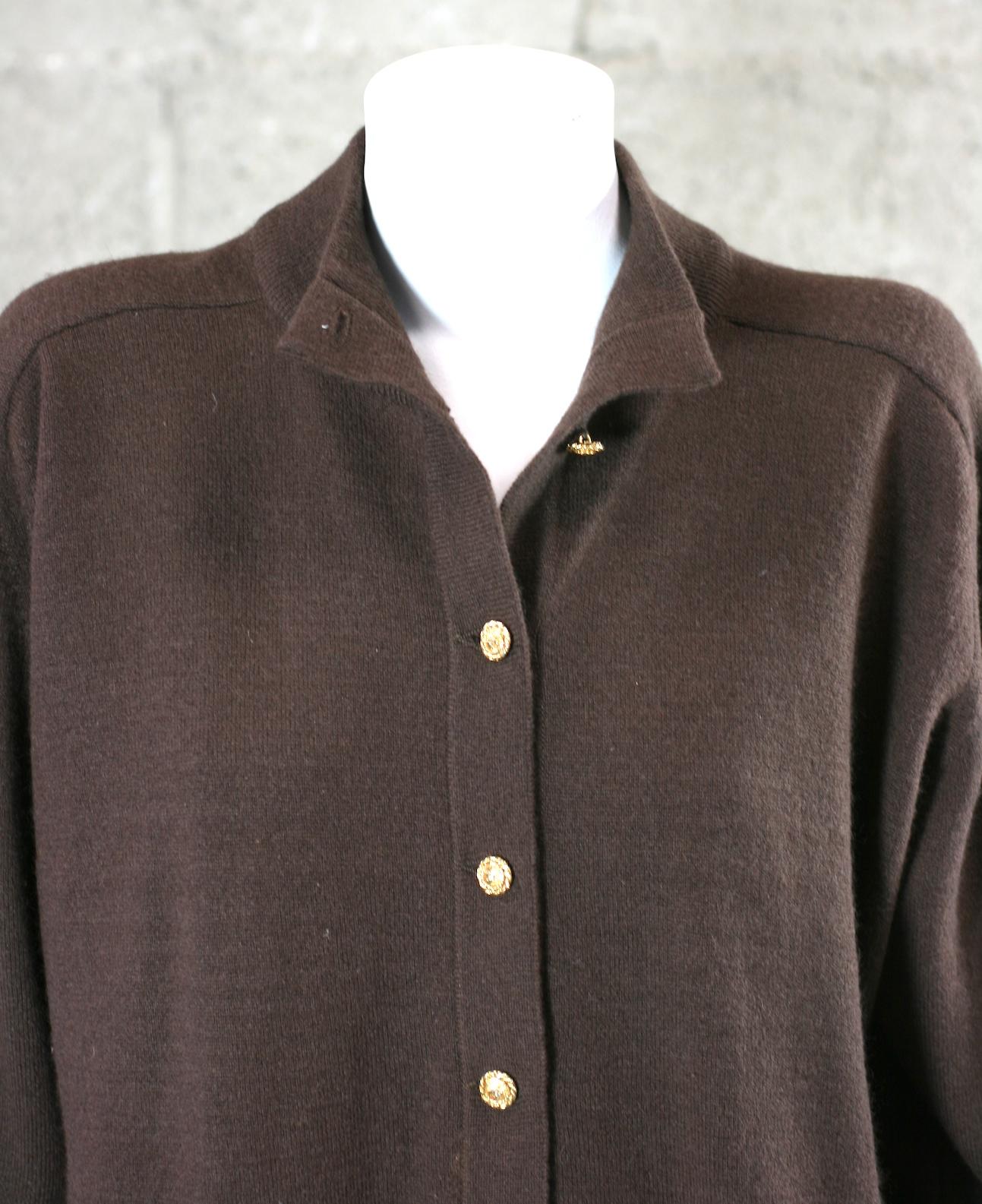 Chanel Cashmere Sweater Tunic from the 1990's. Deep chestnut cashmere knit with gold CC logo buttons. The bottom button has been replaced with a genuine CC button and is not noticeable when worn. Longer length great with leggings and jeans. 
Size 40