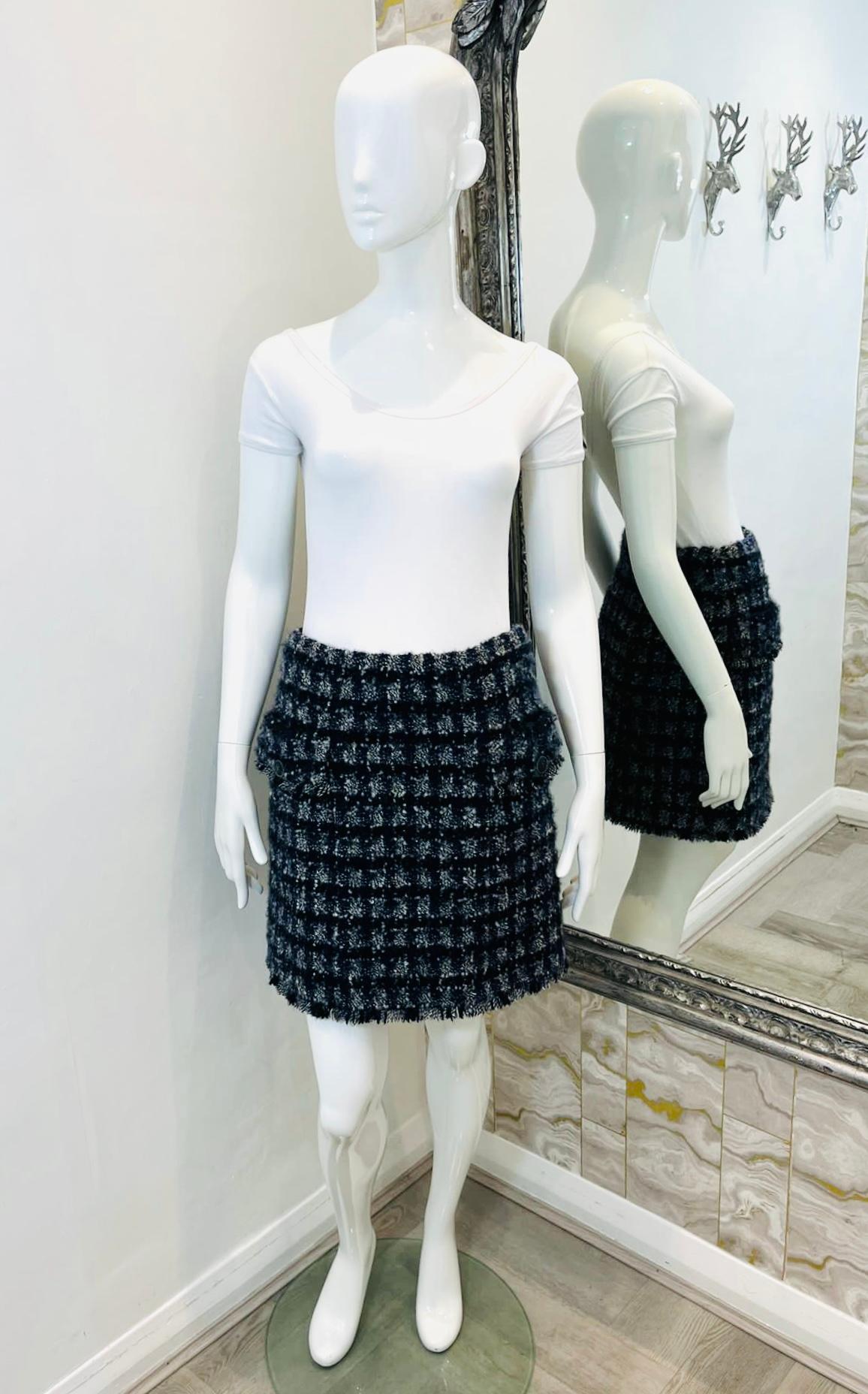 Brand New - Chanel Cashmere, Wool & Silk Tweed Skirt

 Navy, mini skirt designed with Chanel's signature tweed in black, ecru and red.

Styled with flap pockets to the sides embellished with round buttons, detailed

with gold 'CC' logo to the centre
