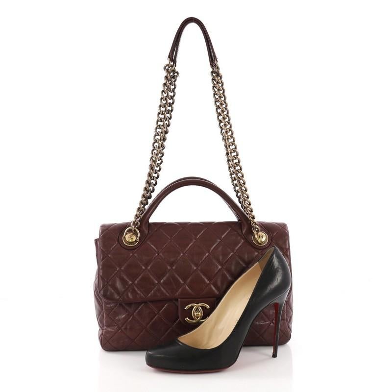 This Chanel Castle Rock Flap Bag Quilted Glazed Calfskin Medium, crafted in burgundy quilted glazed calfskin leather, features dual rolled handles, chunky chain-link strap, exterior back pocket and aged gold-tone hardware. Its CC turn-lock closure