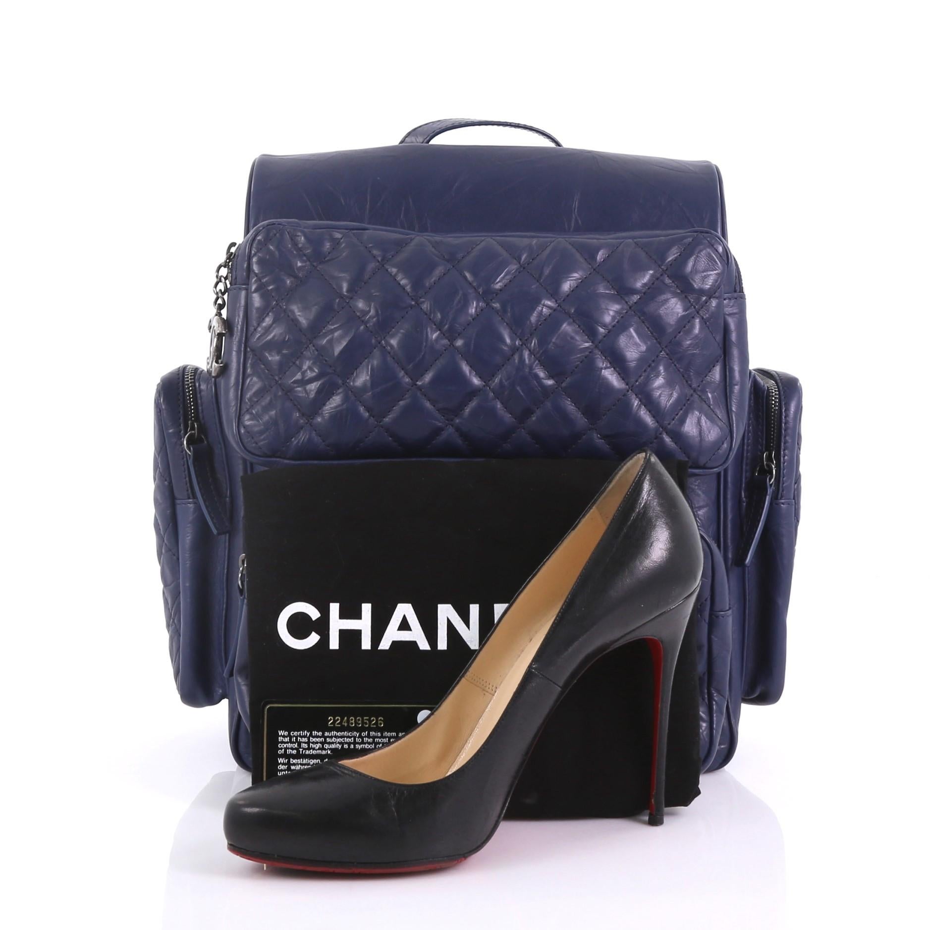 This Chanel Casual Rock Airlines Backpack Quilted Calfskin Medium, crafted from blue quilted calfskin, features a flat top handle, dual leather straps with chain links, four exterior zip pockets, and aged silver-tone hardware. It opens to a blue