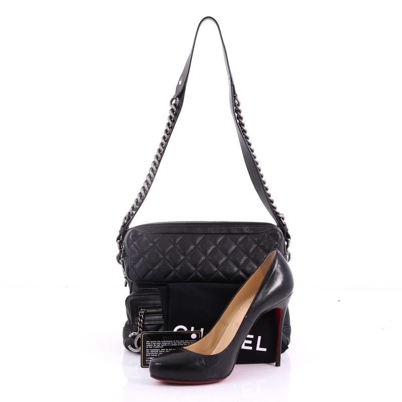 This Chanel Casual Rock Airlines Shoulder Bag Quilted Goatskin Medium, crafted in black quilted goatskin, features a leather strap with chain-link accents, an exterior front zip pocket, and aged silver-tone hardware. Its zip closure opens to a black