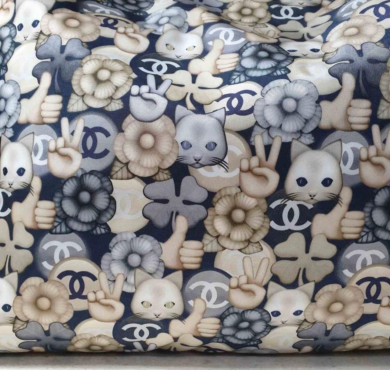 Chanel Nylon Cat Emoticon Tote from the 16K Collection.

Crafted in Navy Gold nylon quilted fabric.

This bag features cat and emoji artwork and metallic gold leather top handles.

Lined in navy nylon.

Wallet inside was lost.

Condition is very