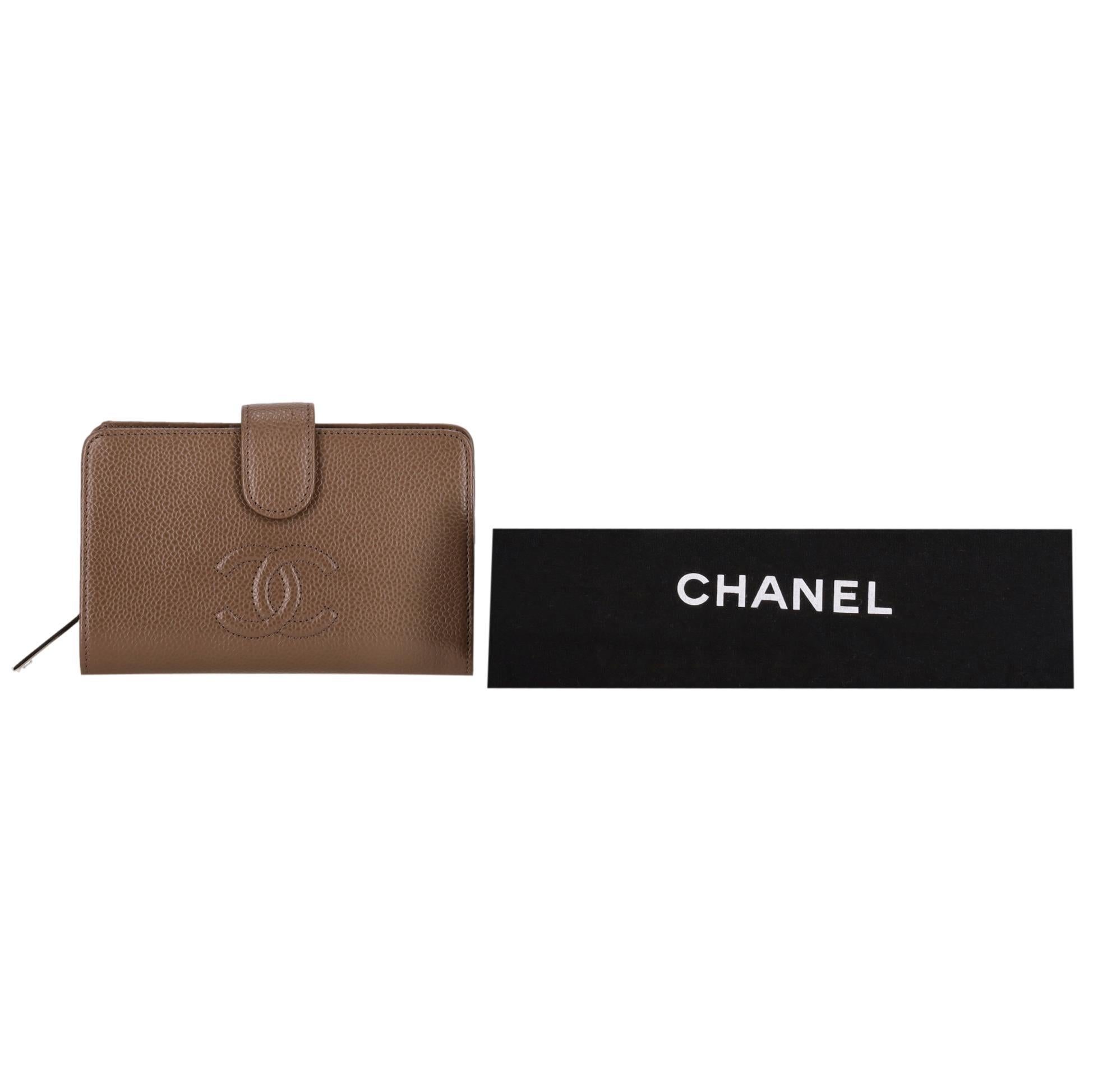 Chanel - Portefeuille en cuir caviar avec logo 'CC' intemporel

Portefeuille en cuir caviar de couleur taupe, avec logo CC surpiqué sur le devant.

Fermeture à bouton-pression donnant accès à plusieurs fentes pour cartes et à une poche zippée pour
