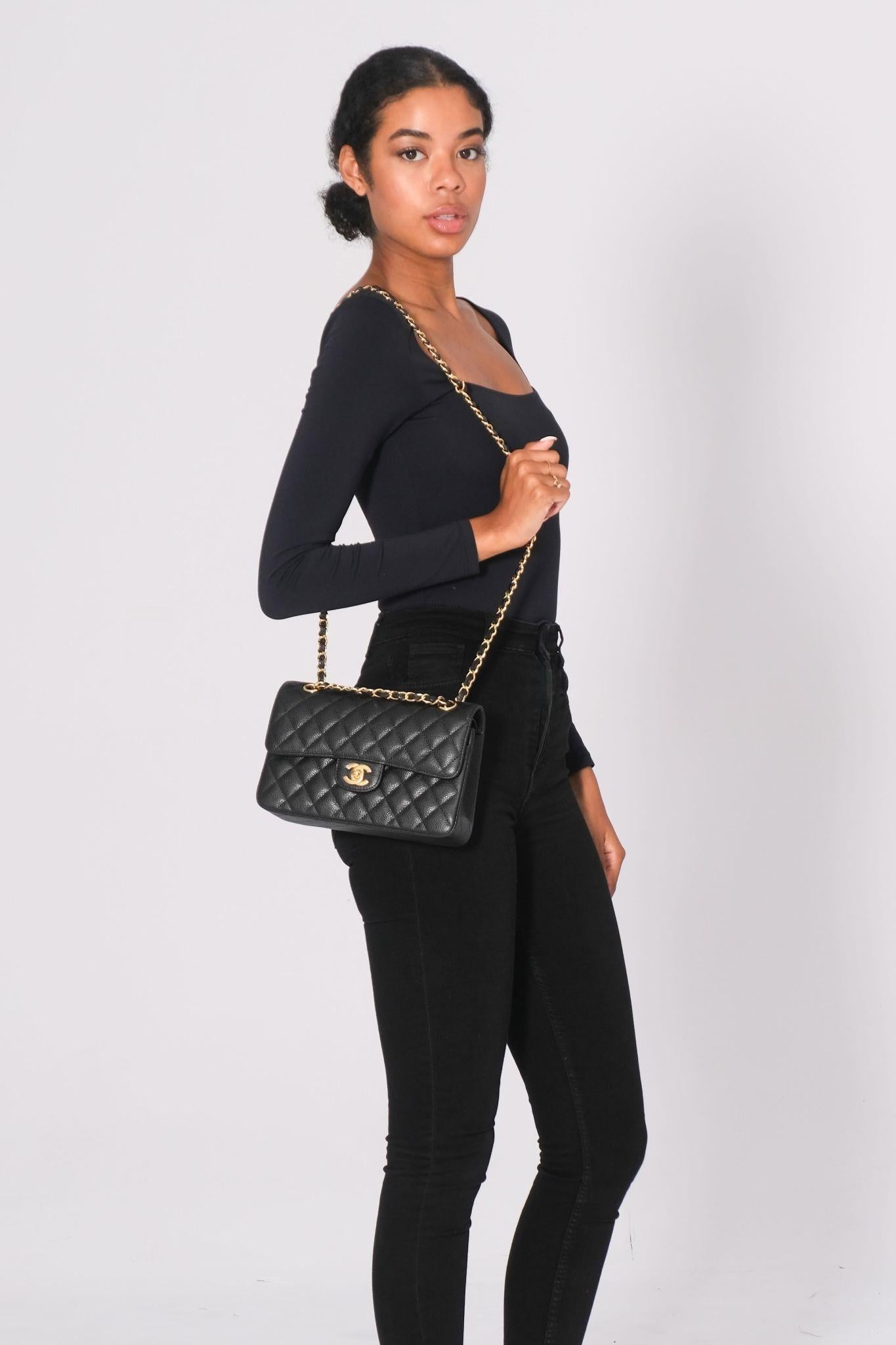 This Chanel shoulder bag is constructed of black diamond-quilted caviar leather. It features gold-tone hardware, a gold chain-link leather-threaded shoulder strap, and a front flap with a gold Chanel CC turn lock closure. The front flap opens to a