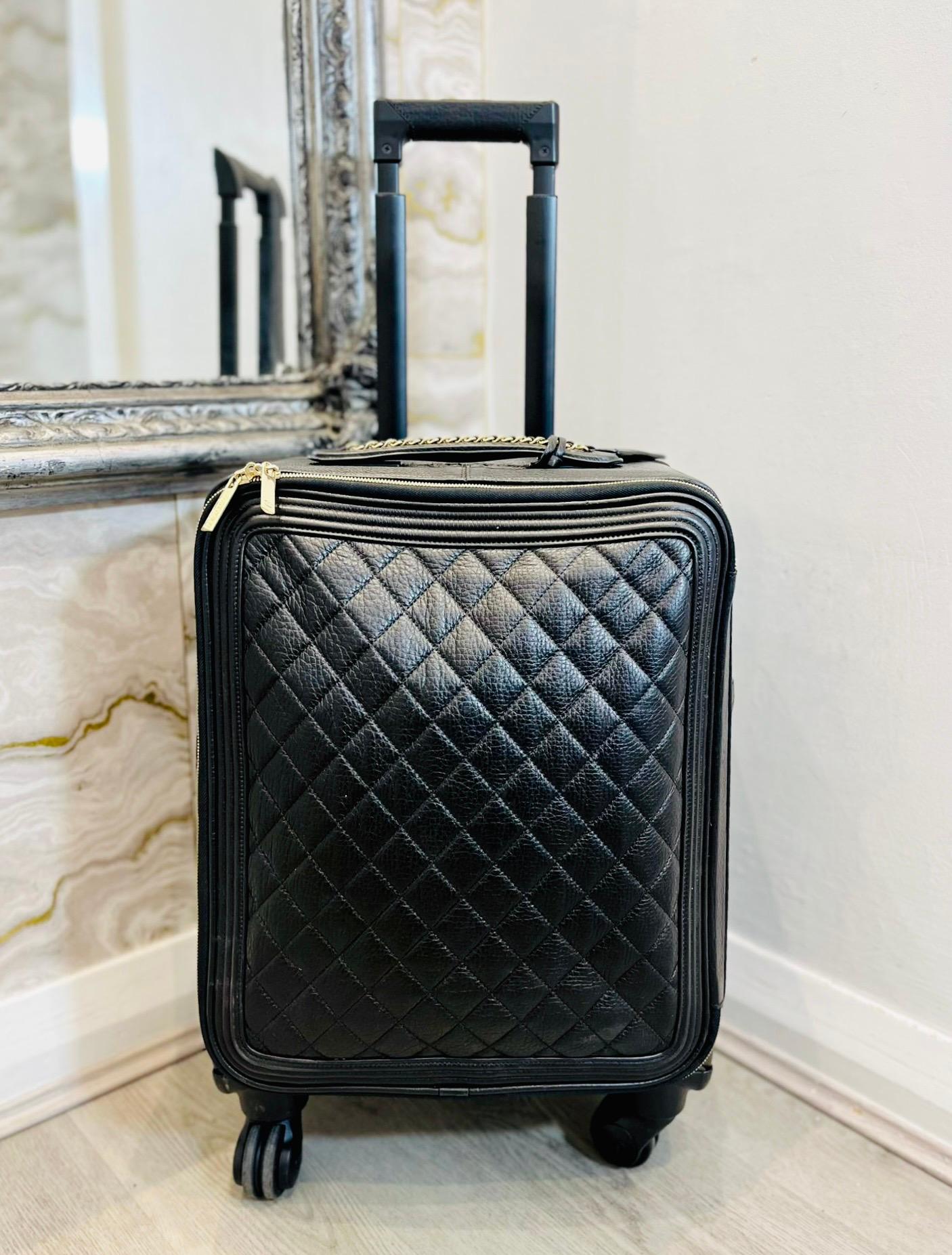 Chanel Caviar Quilted Leather Coco Suitcase

Black trolley bag designed with signature diamond stitching, four wheels and extendable handle.

Detailed with gold hardware, chain embellished top handle with leather 'CC' logo embossed tag. 

Styled