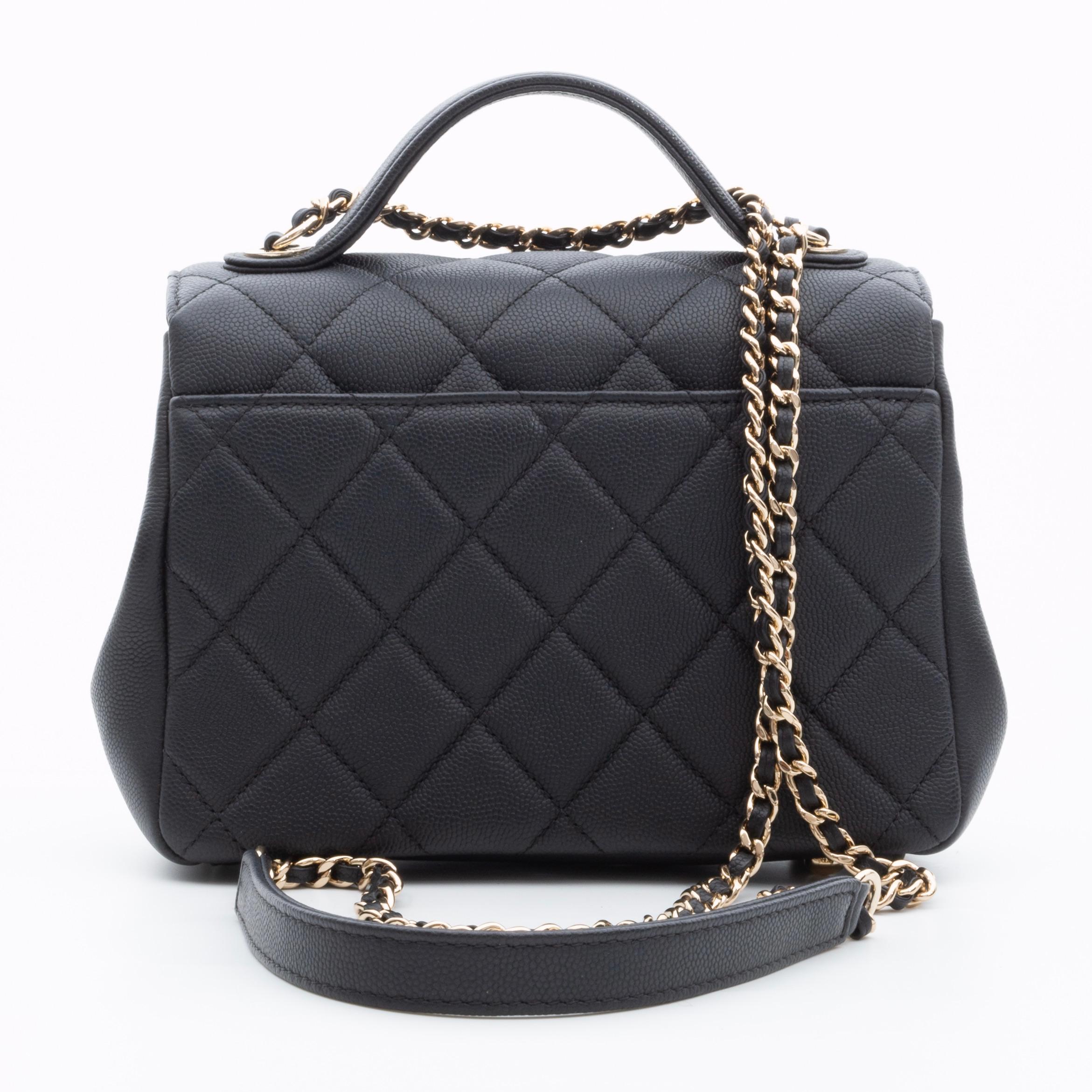 Diese klassische Tasche ist aus genarbtem Kaviar-Kalbsleder mit Rautensteppung in Schwarz gefertigt. Die Umhängetasche verfügt über einen robusten oberen Ledergriff, einen goldenen, mit Leder verflochtenen Schulterriemen mit Schulterpolster, ein