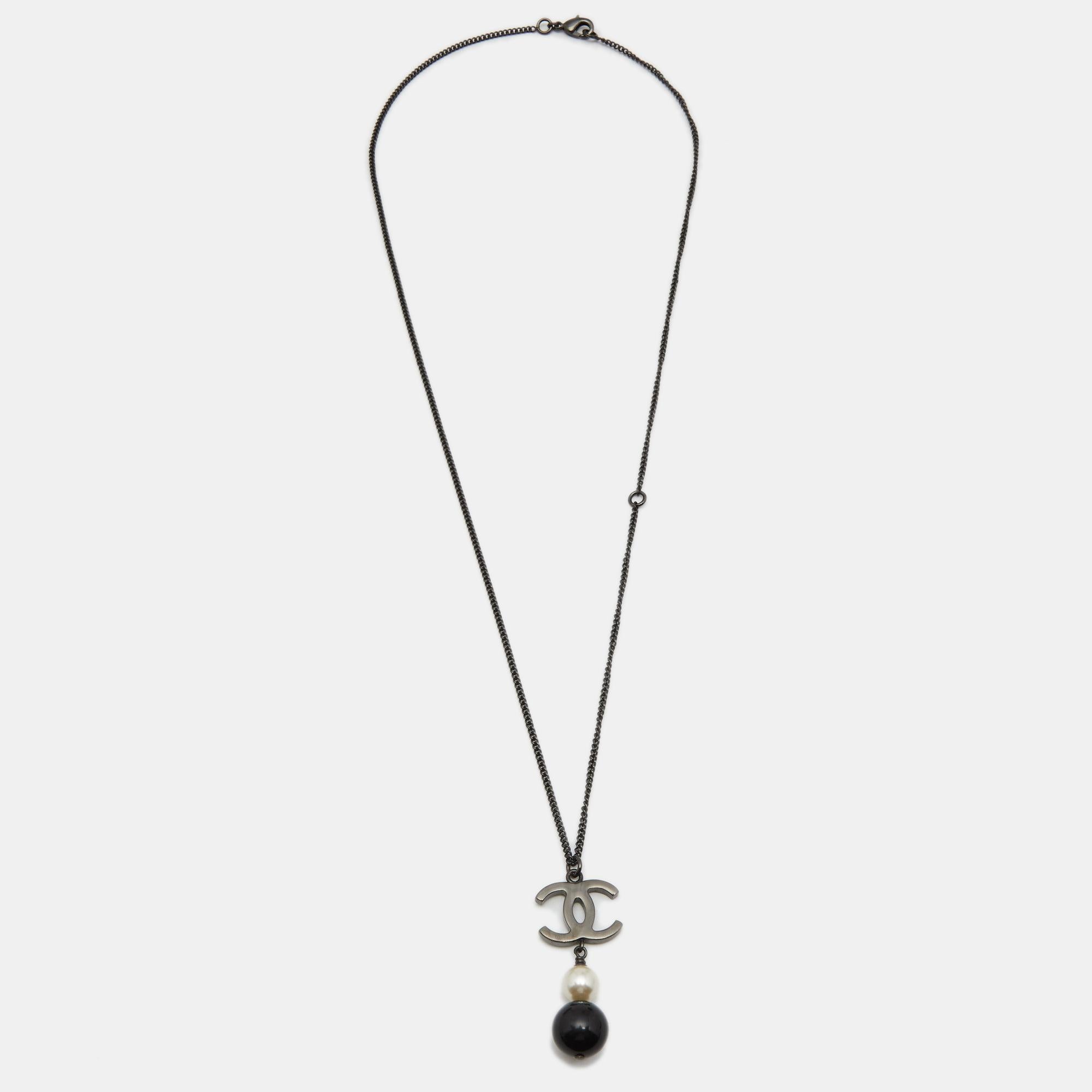 This pendant necklace from Chanel is a picture of elegance. The gunmetal-tone chain holds the CC logo charm, a faux pearl, and a bead. The chain can be secured around the neck with a lobster claw closure.

Includes: Original Box, Original Pouch

