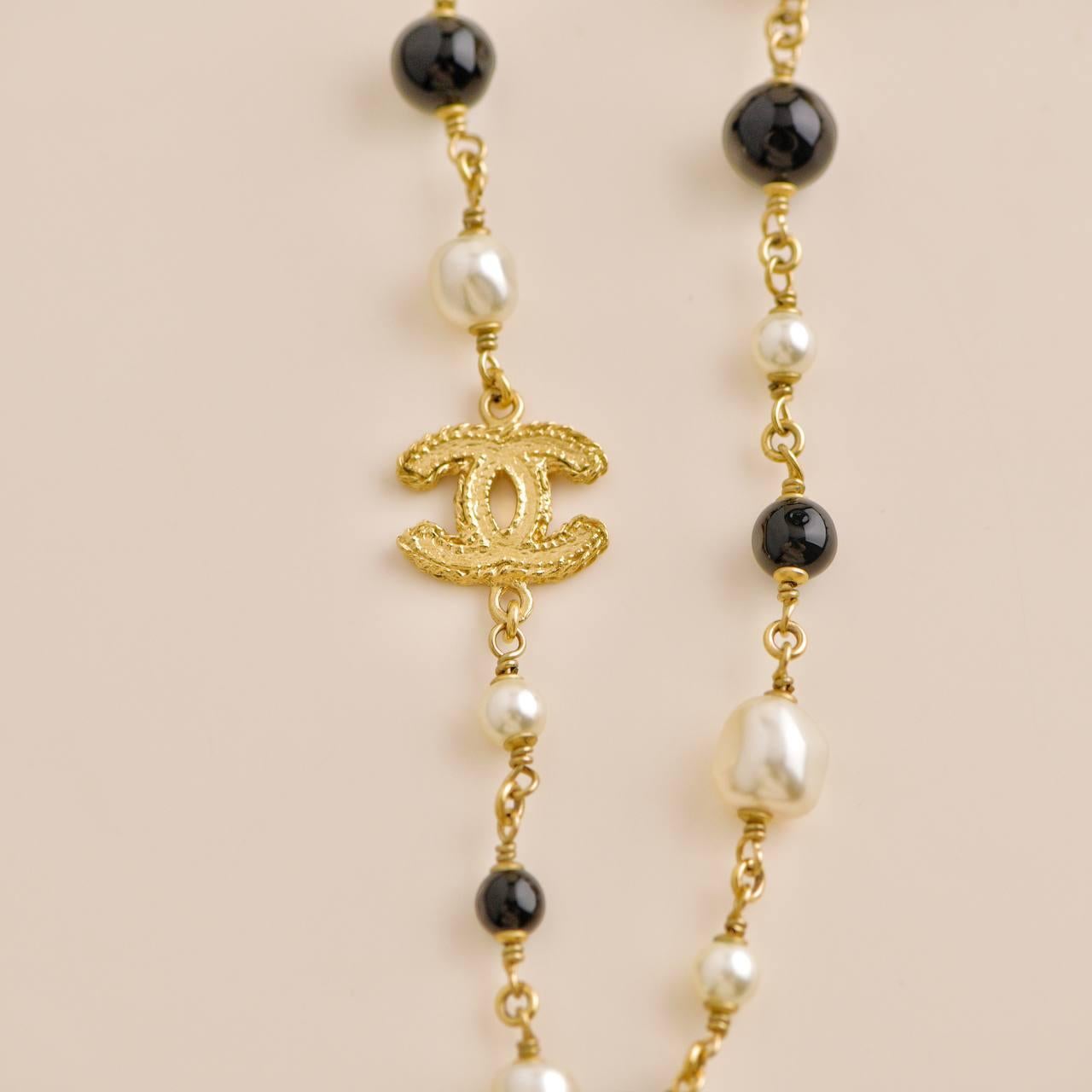 Chanel CC Collier long de couleur or avec perles noires et crème en vente 1