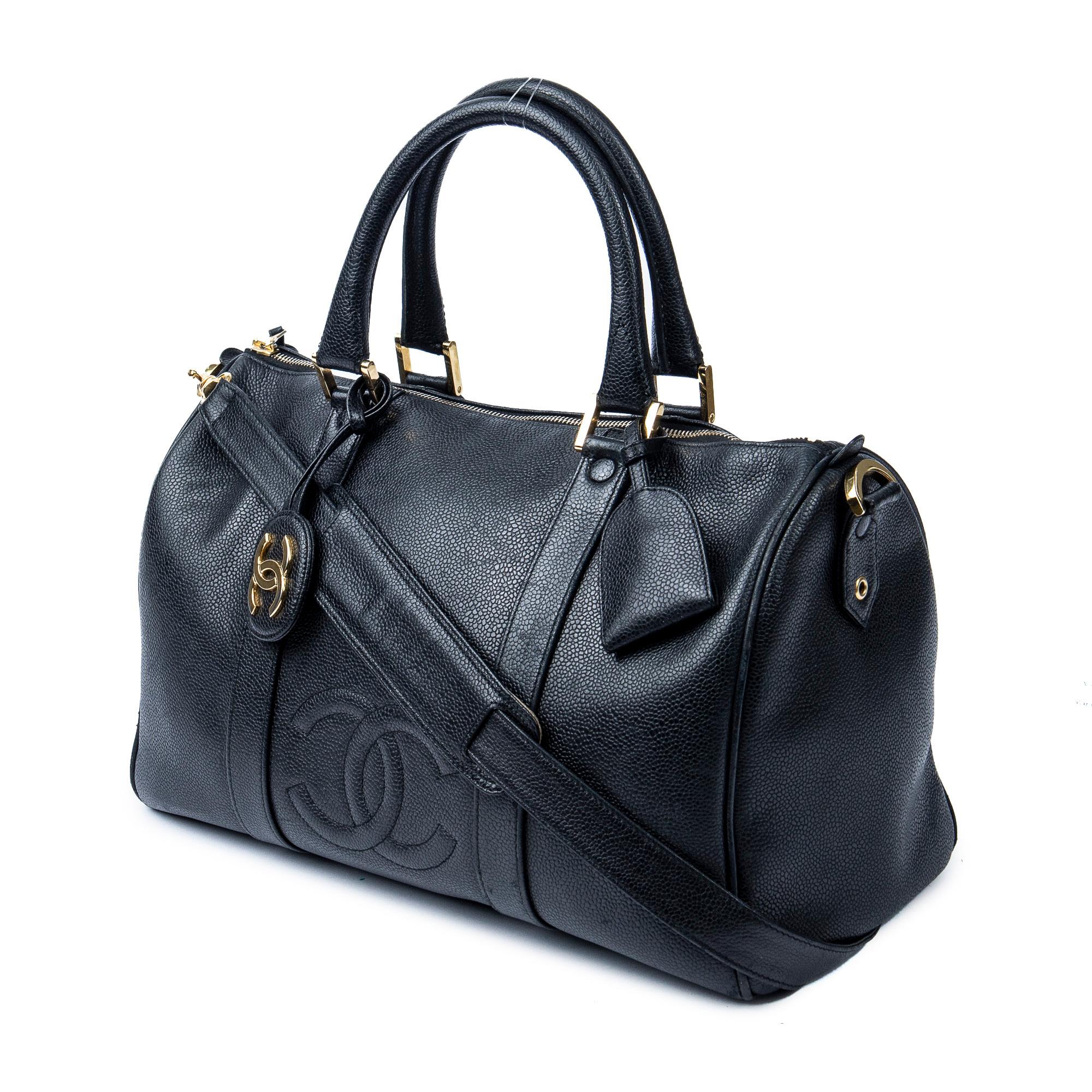 Step into the glamorous world of Chanel with this iconic vintage Chanel small weekender which could also be used as a daily carry. Crafted from luxurious black calfskin leather, this statement piece exudes elegance. The sleek black leather straps