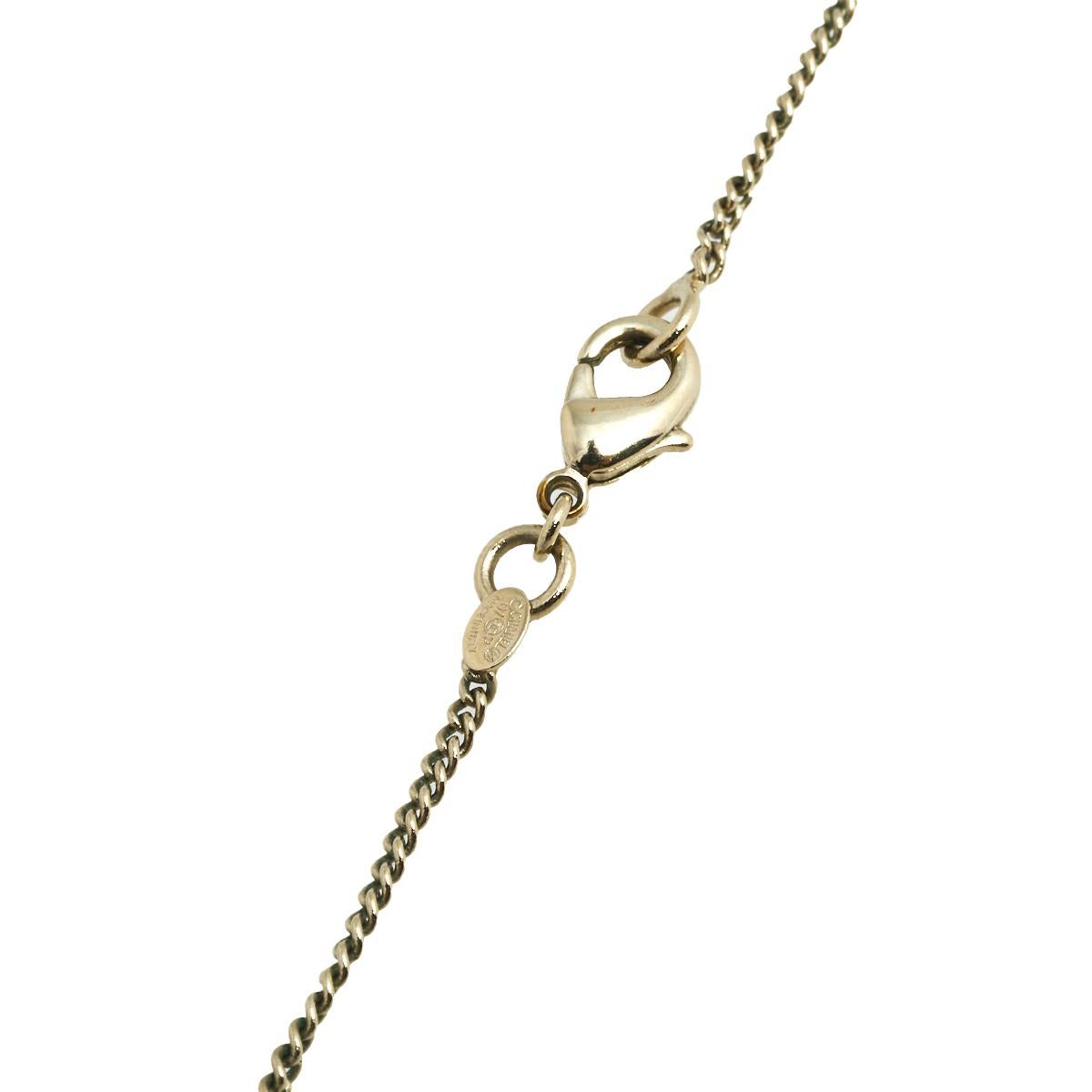 This lovely necklace by Chanel will make a timeless addition to your collection. Crafted from gold-tone metal, this gorgeous creation has a chain that holds a pendant of a dangling CC logo and the iconic flap bag as a charm. It is finished with