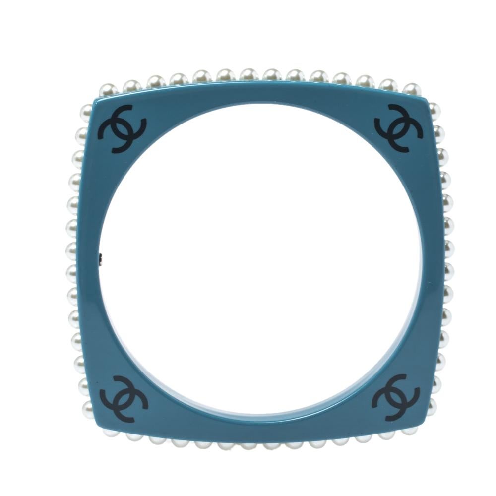 The Chanel CC bracelet is crafted to grant elegance to your wrist and a subtle look to your attire. The blue resin bangle is high on style which is adorned with faux pearls and CC motifs. This must-have bracelet is an ideal piece for everyday