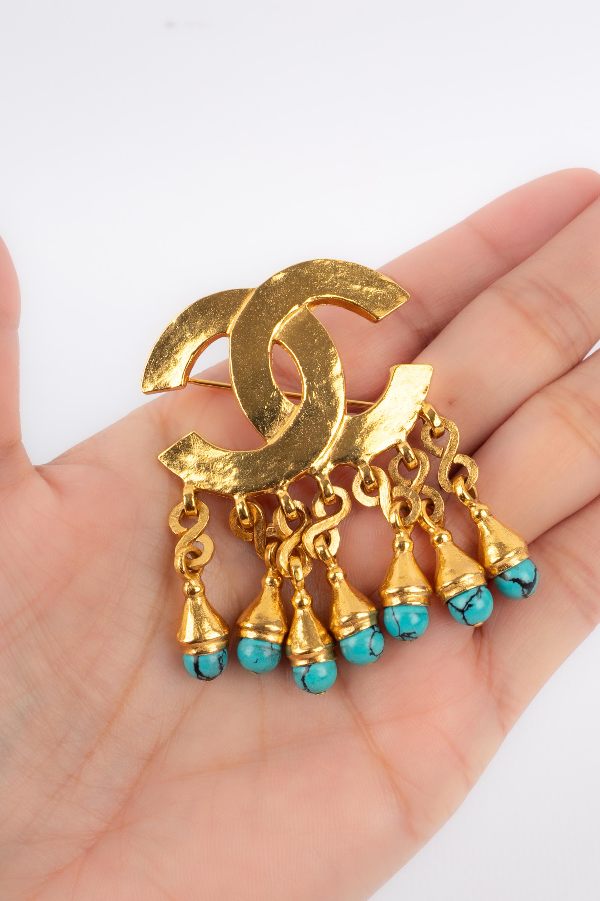 CHANEL - (Made in France) Golden metal cc brooch with tiny glass pearls resembling turquoise. 1997 Spring-Summer Collection.

Condition:
Very good condition

Dimensions:
5.5 cm x 4 cm

BRB120