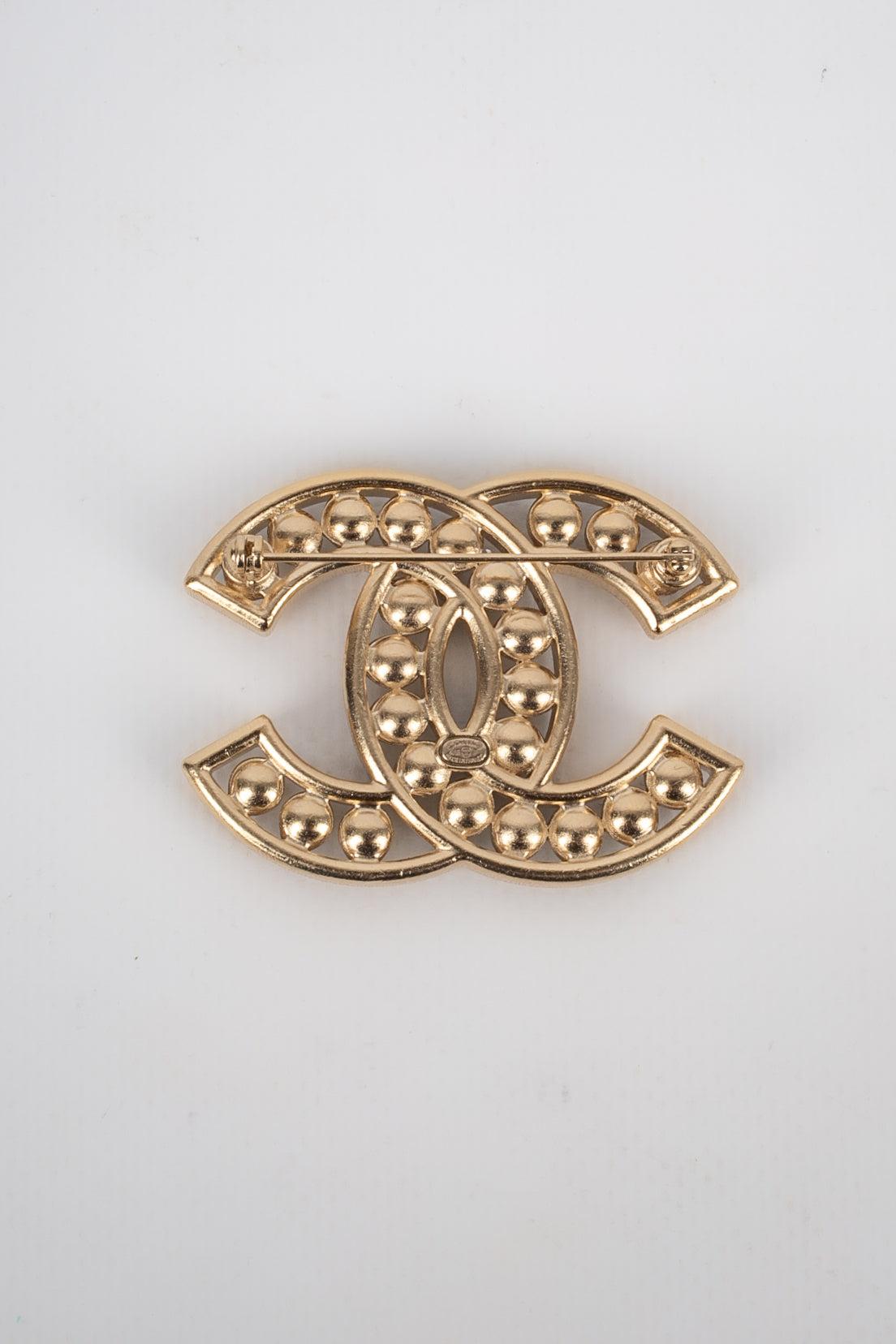 Chanel - (Made in France) Light-golden metal cc brooch ornamented with Swarovski rhinestones and costume pearls. 2018 Collection.
 
 Additional information: 
 Condition: Very good condition
 Dimensions: 5.5 cm x 4 cm
 Period: 21st Century
 
 Seller